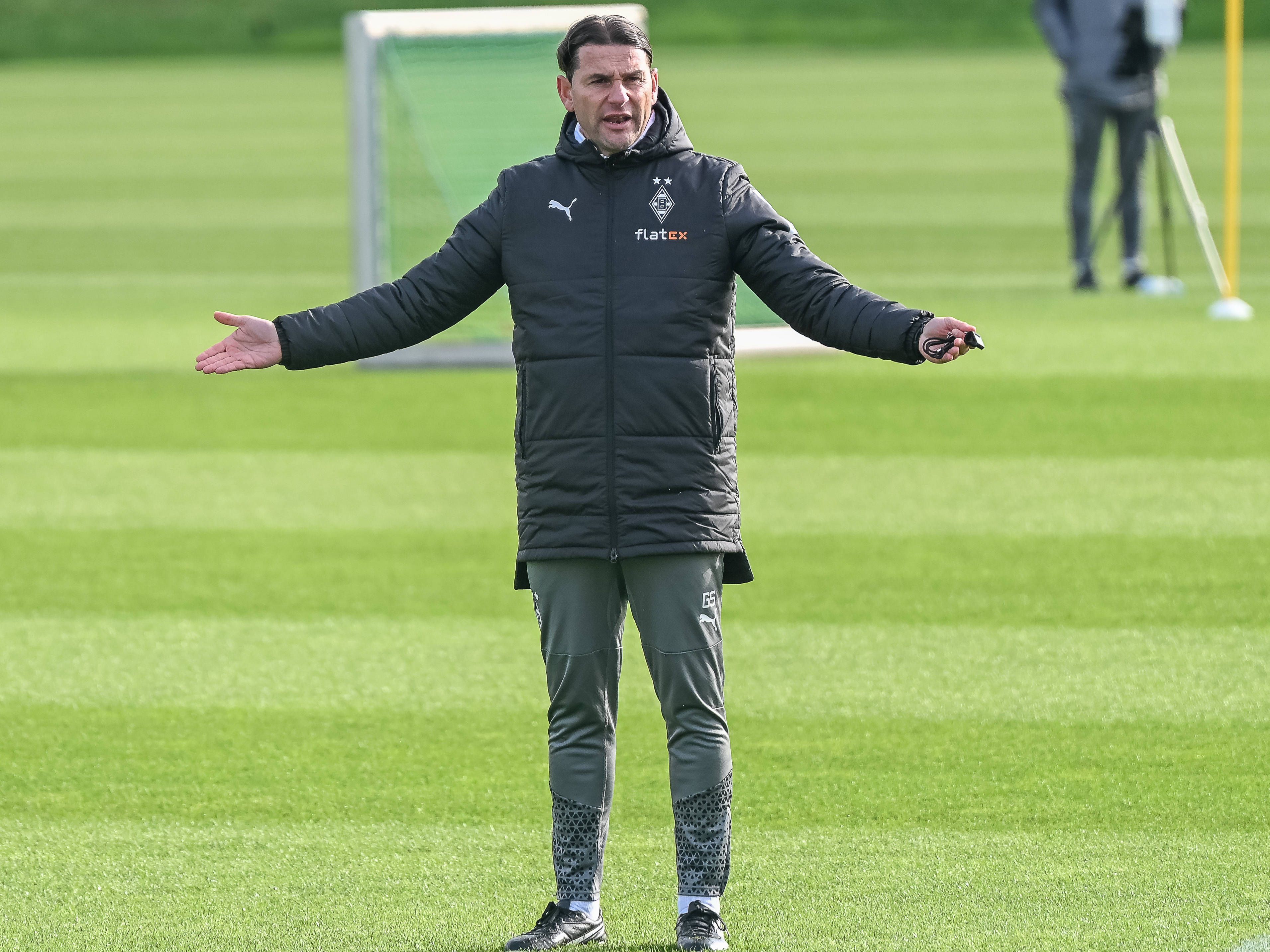 Gerardo Seoane streckt beide Arme bei einem Borussia-Training zeitlich raus.