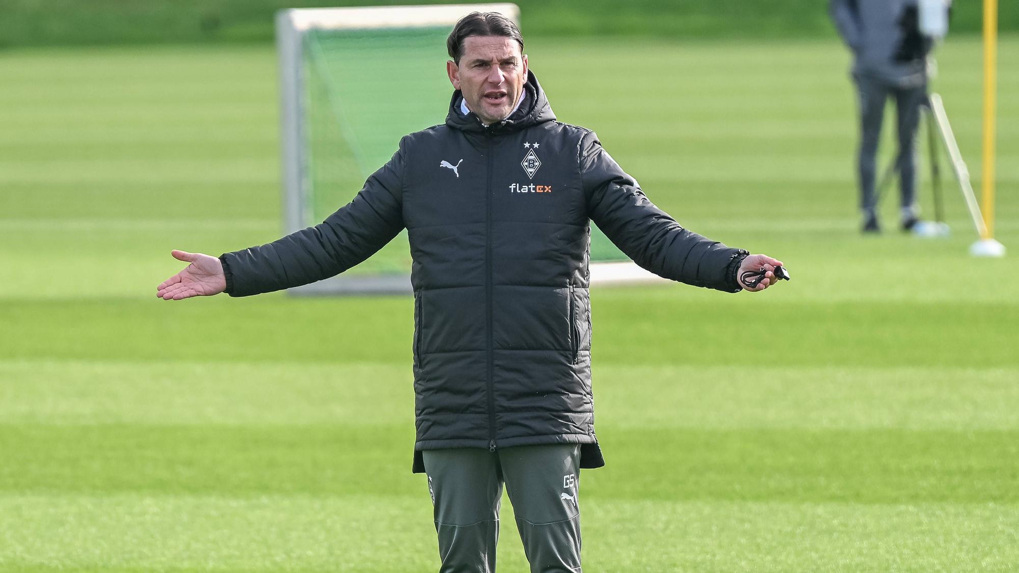 Gerardo Seoane streckt beide Arme bei einem Borussia-Training zeitlich raus.