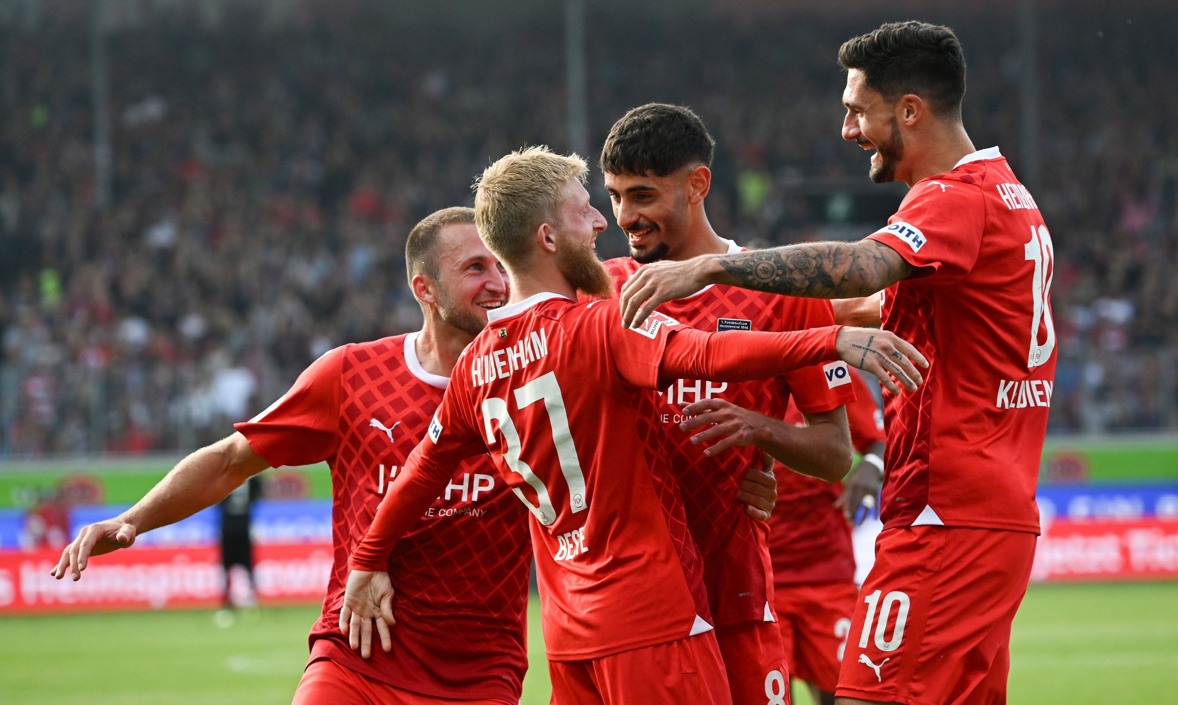 Heidenheims Jan-Niklas Beste freut sich über seinen Treffer zum 1:0 zusammen mit seinen Teamkollegen.