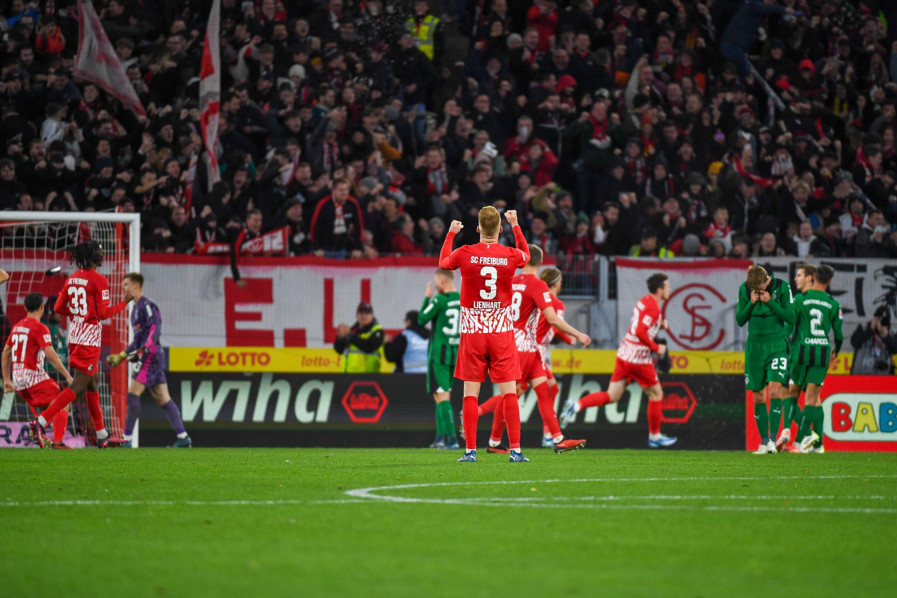 Die Freiburg-Spieler bejubeln den Treffer zum 3:3 gegen Borussia Mönchengladbach, die Gladbach-Spieler reagieren enttäuscht.