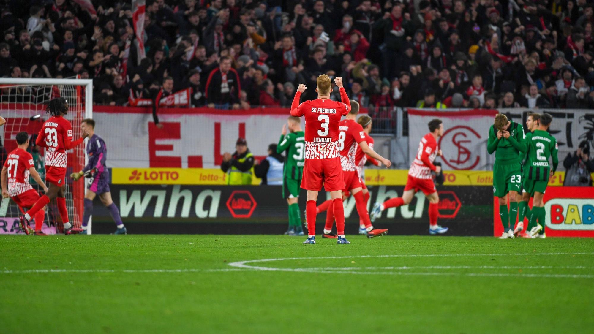 Die Freiburg-Spieler bejubeln den Treffer zum 3:3 gegen Borussia Mönchengladbach, die Gladbach-Spieler reagieren enttäuscht.