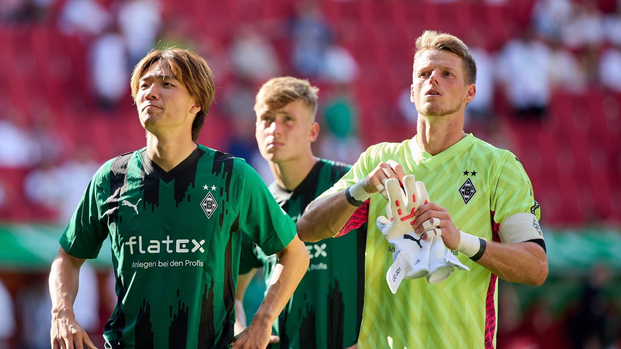 Ko Itakura und Jonas Omlin stehen vor der Gladbach-Fankurve beim Spiel in Augsburg.