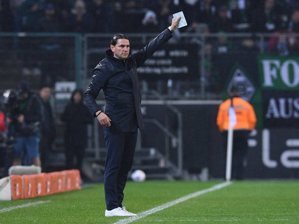 Coach von Borussia Mönchengladbach hält einen Zettel in der rechen Hand.