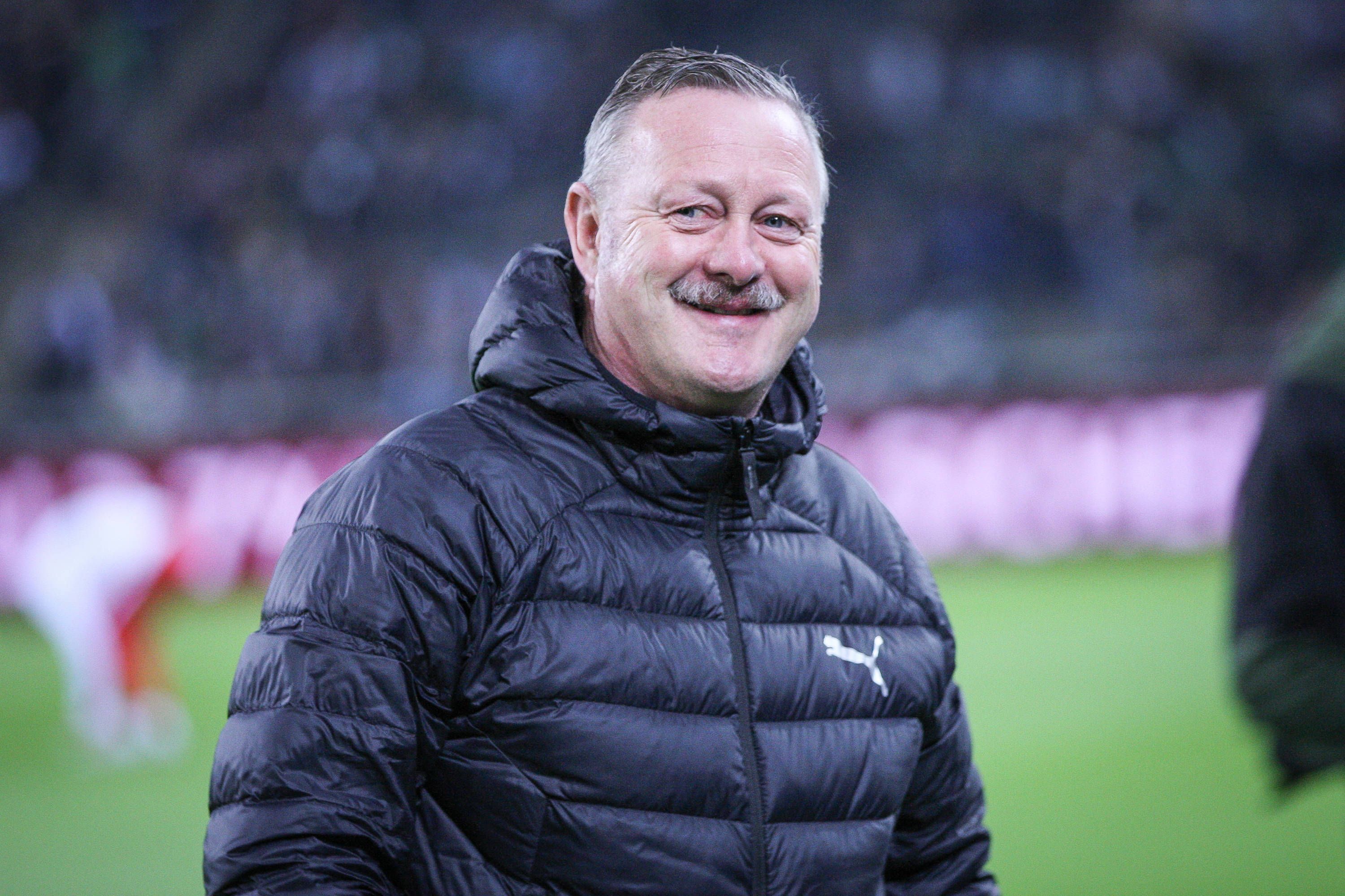 Roland Virkus lächelt am Spielfeldrand im Borussia-Park.