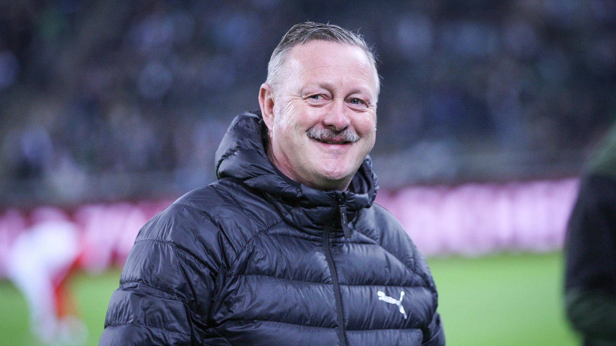 Roland Virkus lächelt am Spielfeldrand im Borussia-Park.