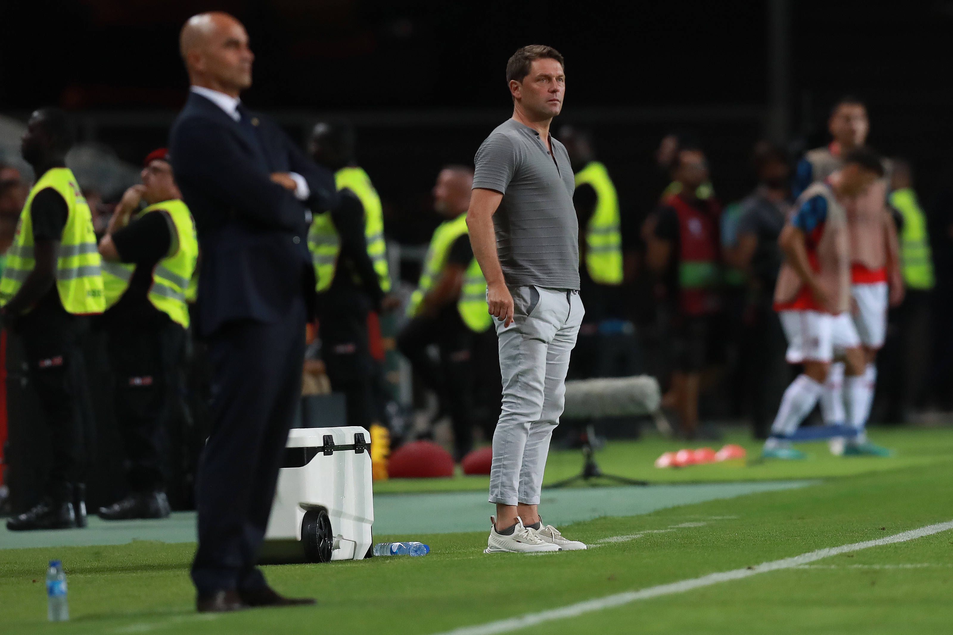 Luc Holtz steht neben Roberto Martinez am Spielfeldrand.