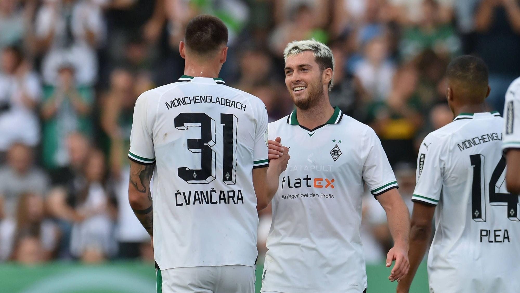 Tomas Cvancara und Joe Scally klatschen sich lächelnd ab.