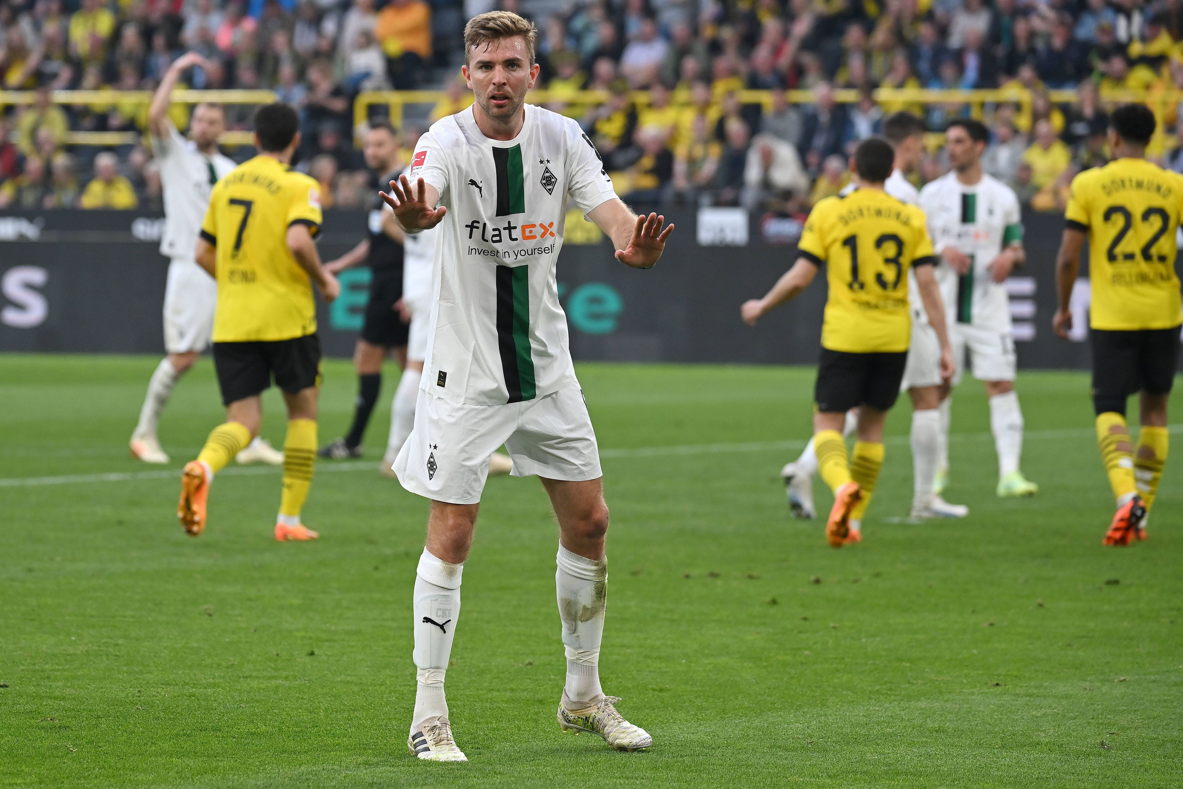 Christoph Kramer will seine Mitspieler nach einem Gegentor beruhigen. Im Hintergrund jubeln Dortmund-Spieler.