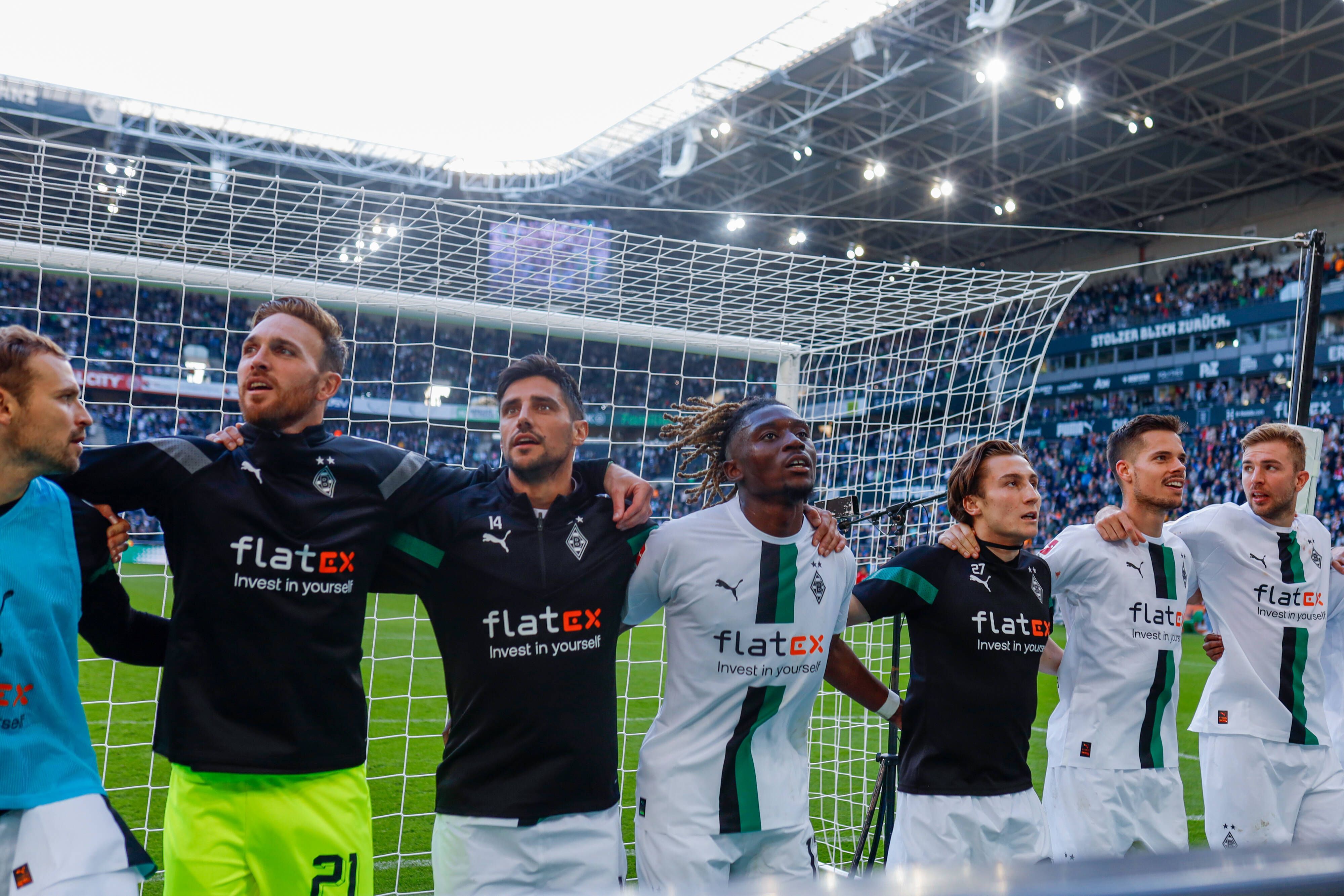 Spieler von Borussia Mönchengladbach hüpfen und feiern mit den Fans.