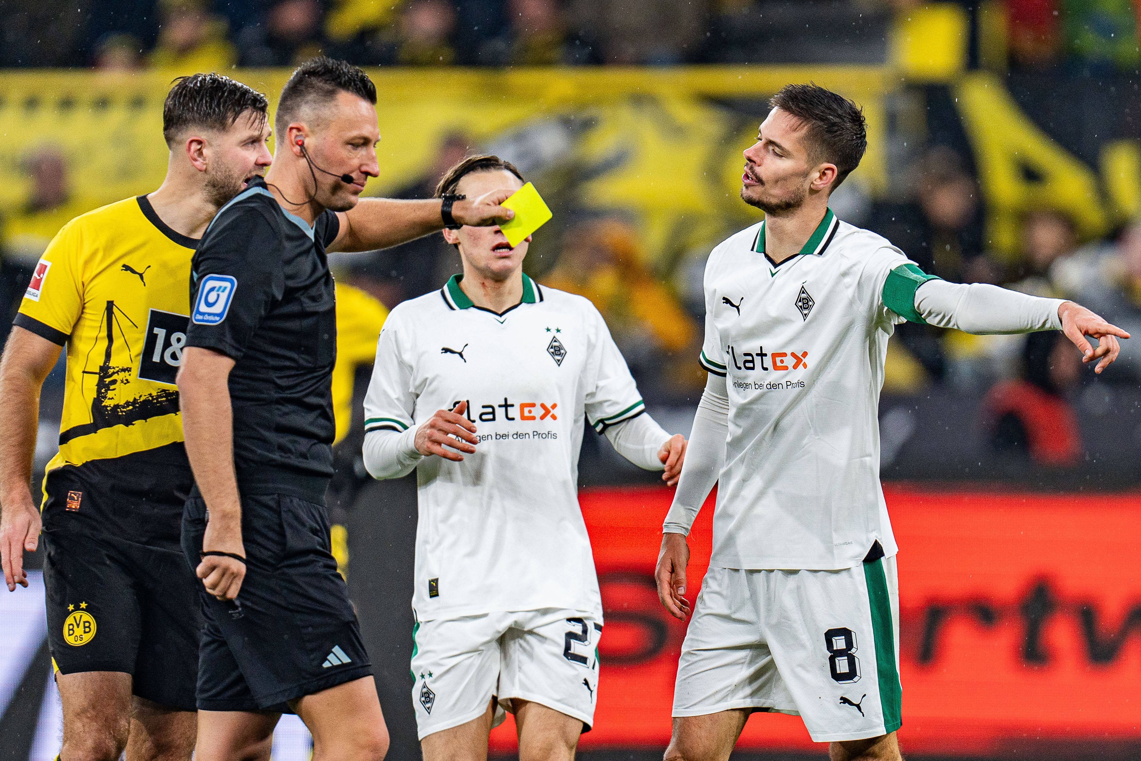 Sven Jablonski zeigt Julian Weigl eine Gelbe Karte.