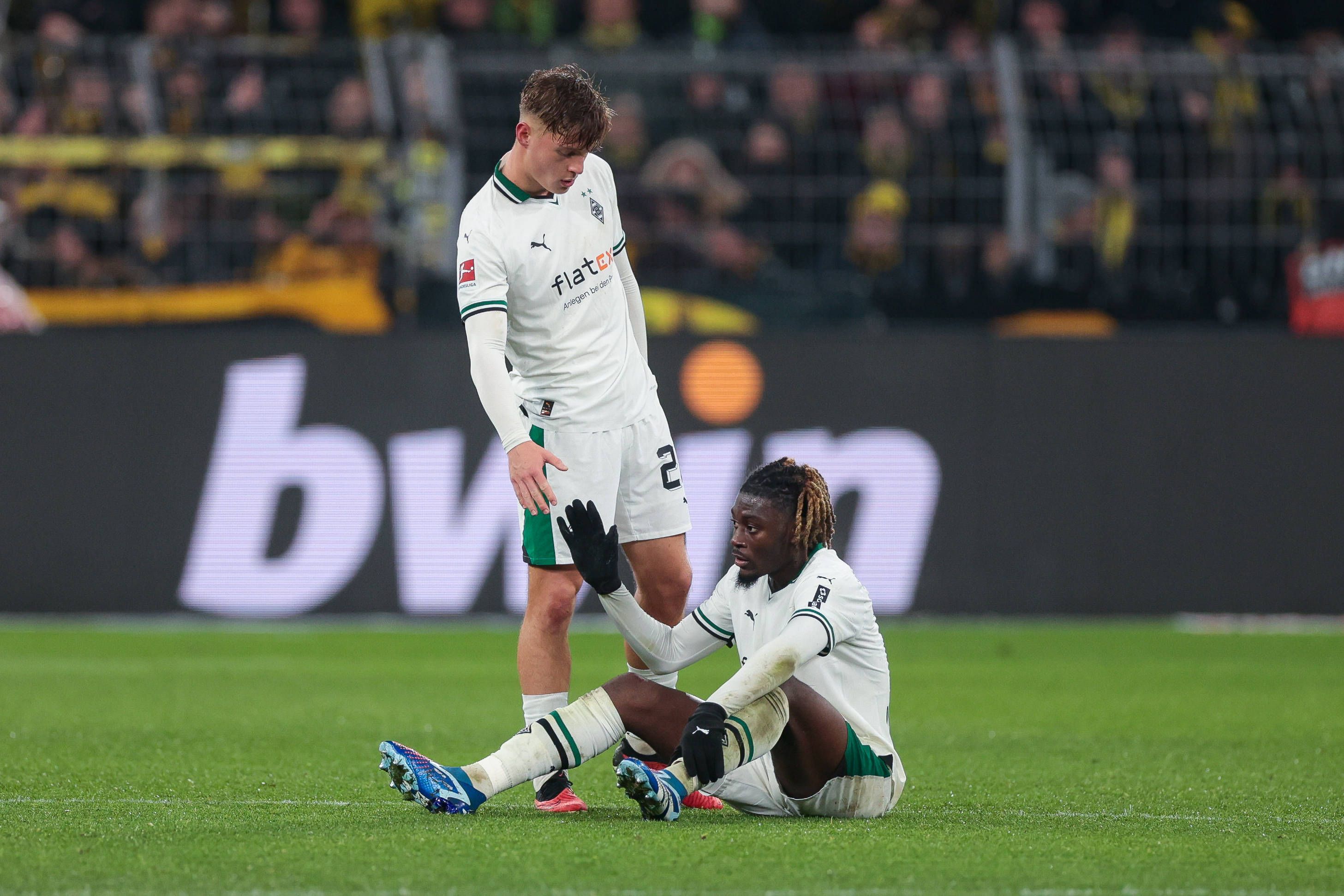 Luca Netz hilft Manu Kone vom Boden auf.