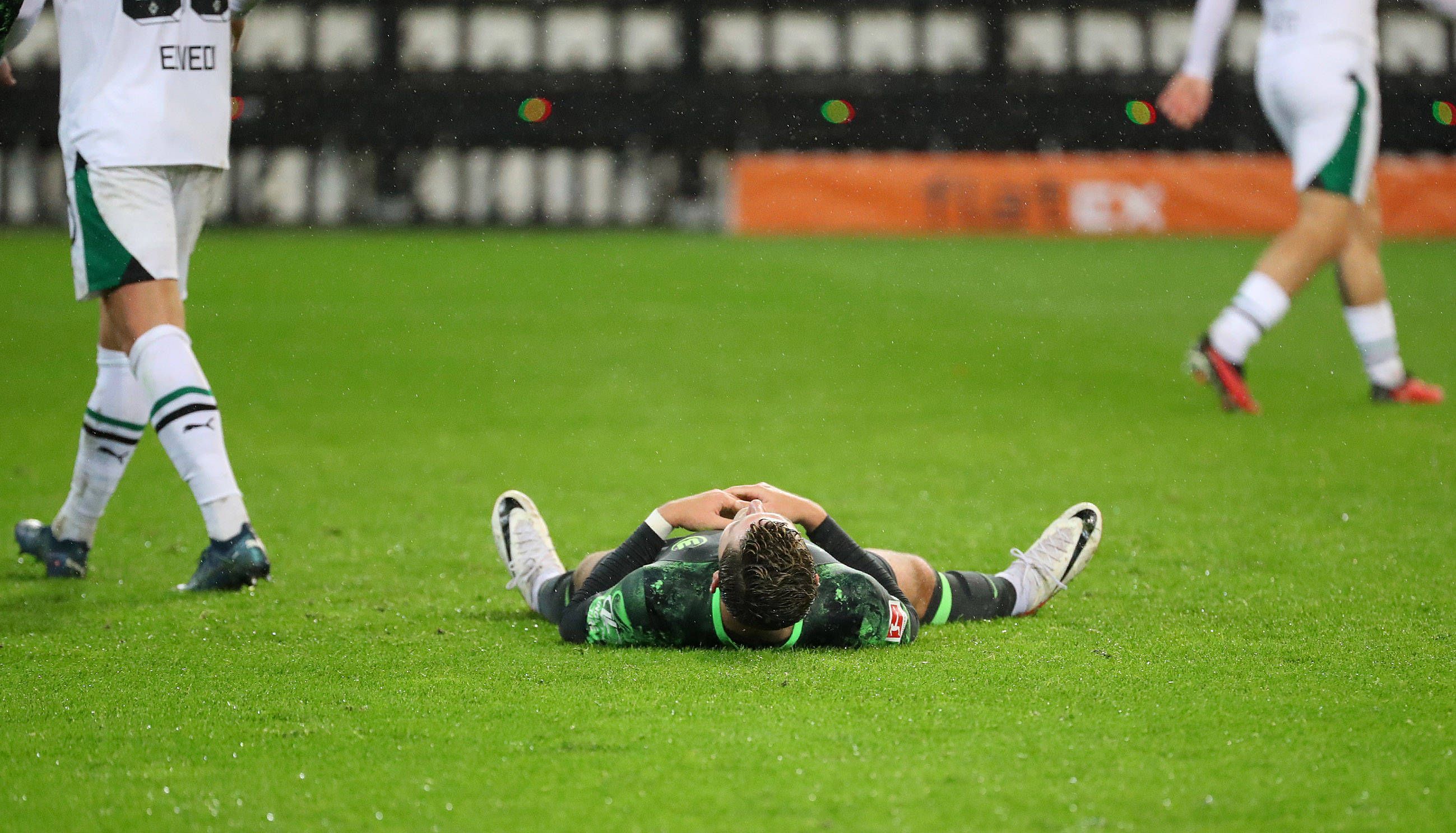 Jonas Wind liegt auf dem Rasen im Borussia-Park.