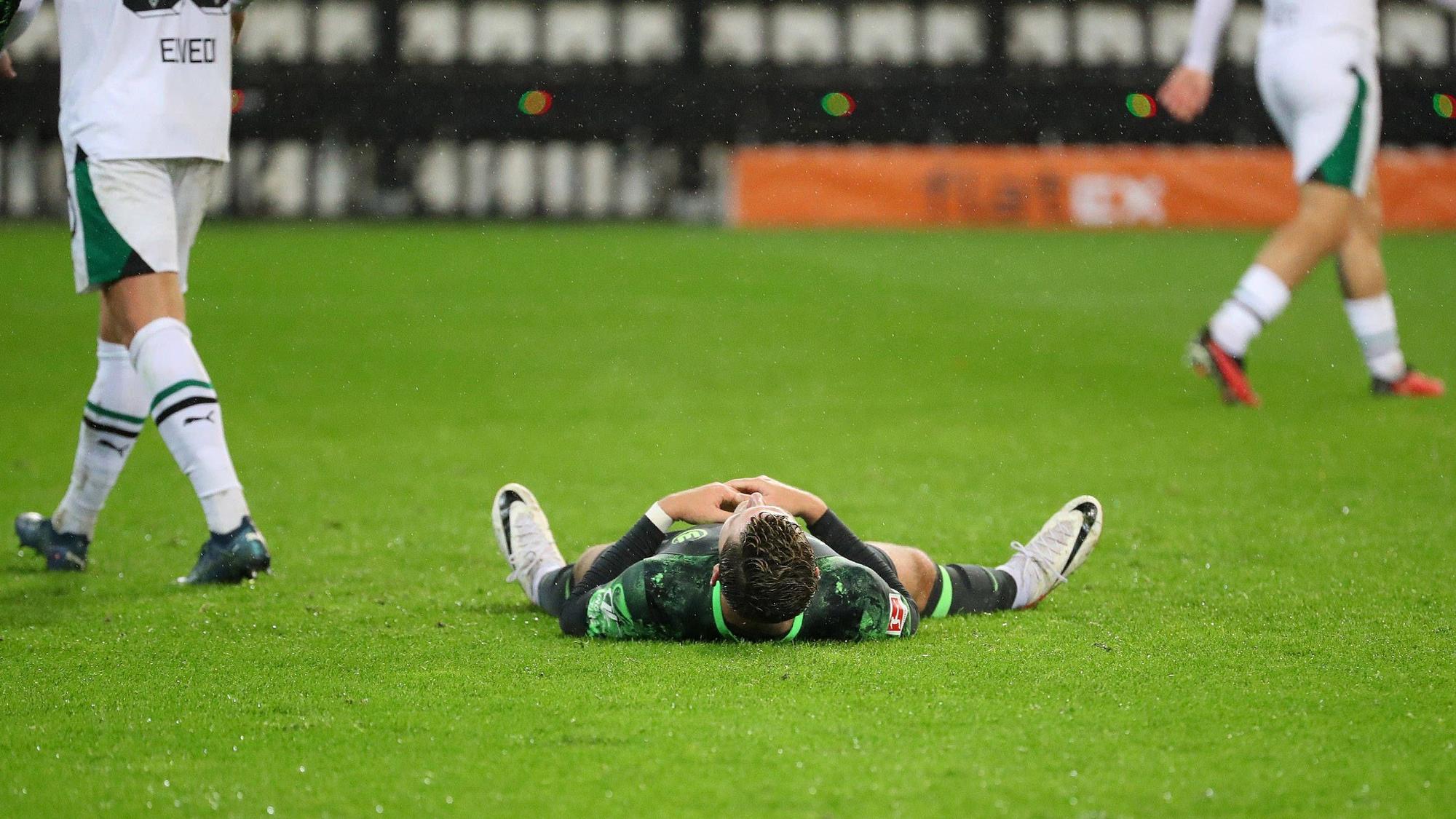 Jonas Wind liegt auf dem Rasen im Borussia-Park.