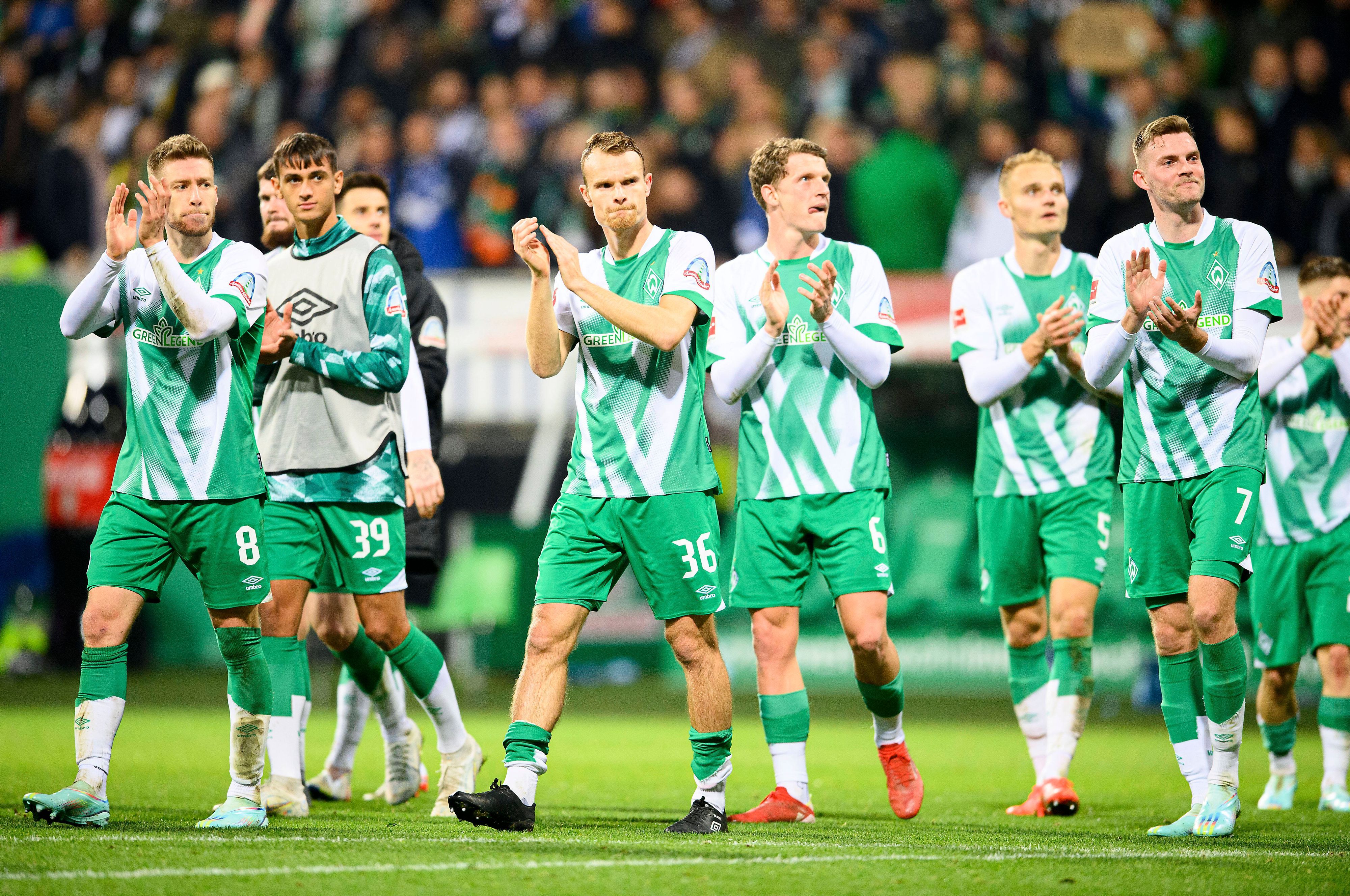 Spieler von Werder Bremen applaudieren ihren Fans.
