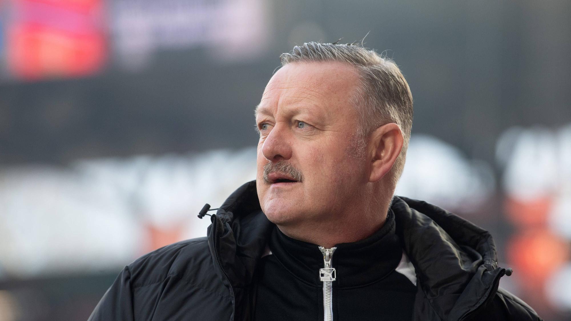 Sport-Geschäftsführer von Borussia Mönchengladbach blickt fokussiert vor einem Spiel.