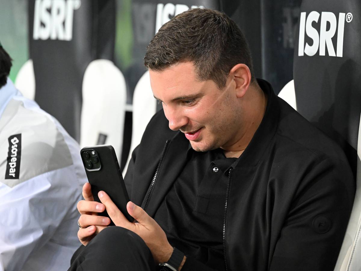 Nils Schmadtke schaut begeistert auf sein Smartphone.