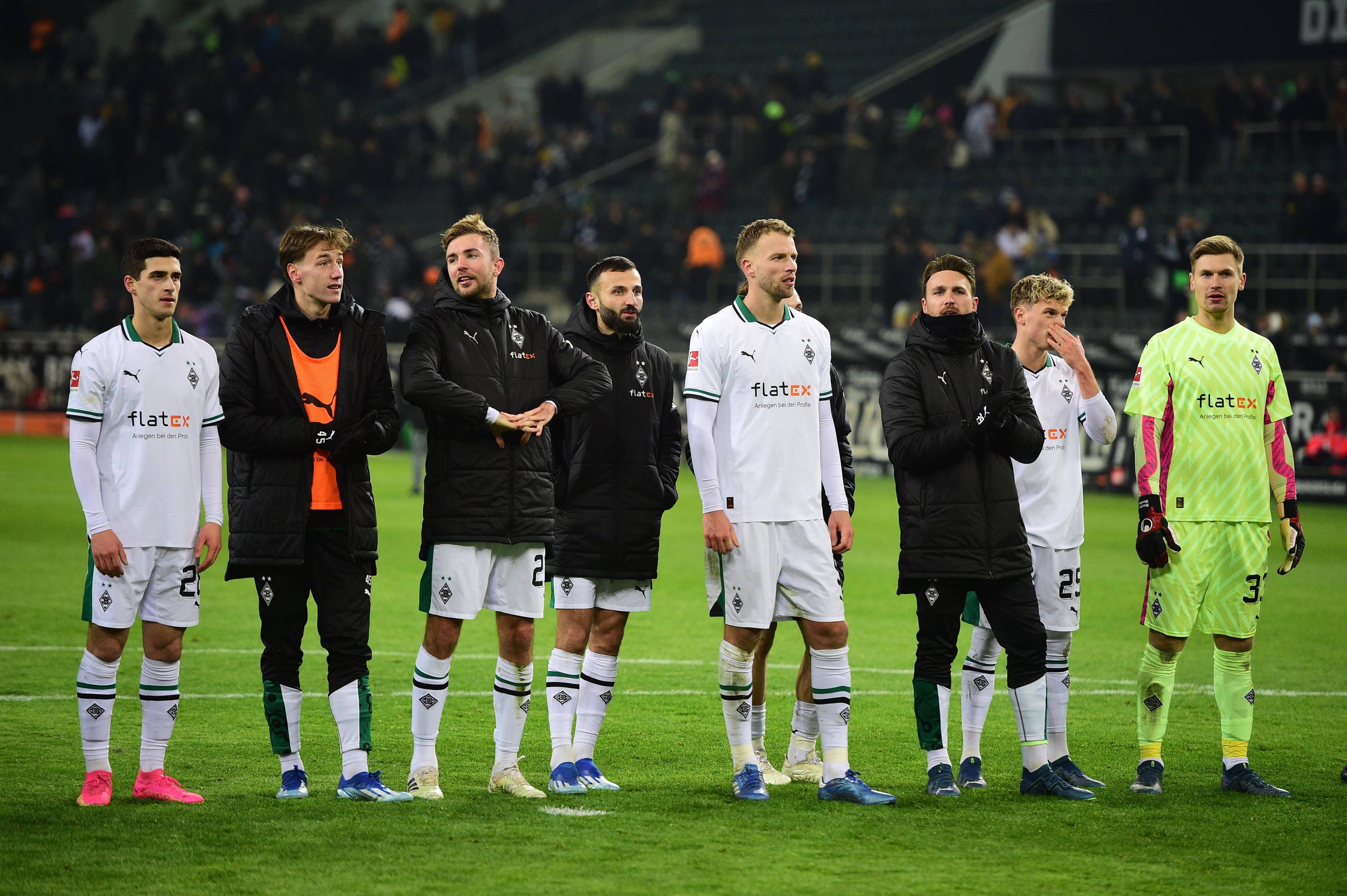 Spieler von Borussia Mönchengladbach stehen nach einem Sieg nebeneinander.
