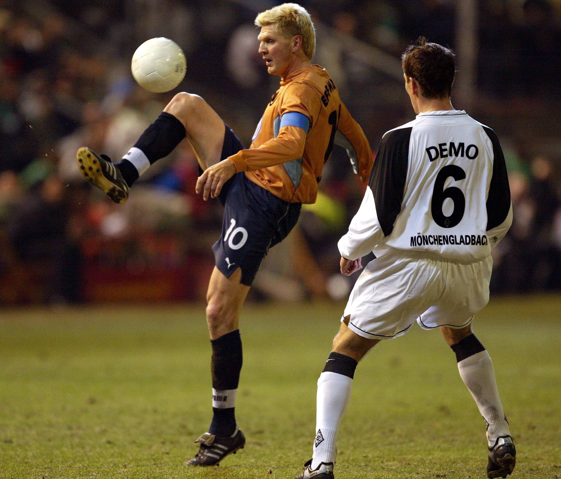Stefan Effenberg im orangen Wolfsburg-Trikot spielt den Ball. Igor Demo versucht im Trikot von Borussia Mönchengladbach dazwischenzugehen.