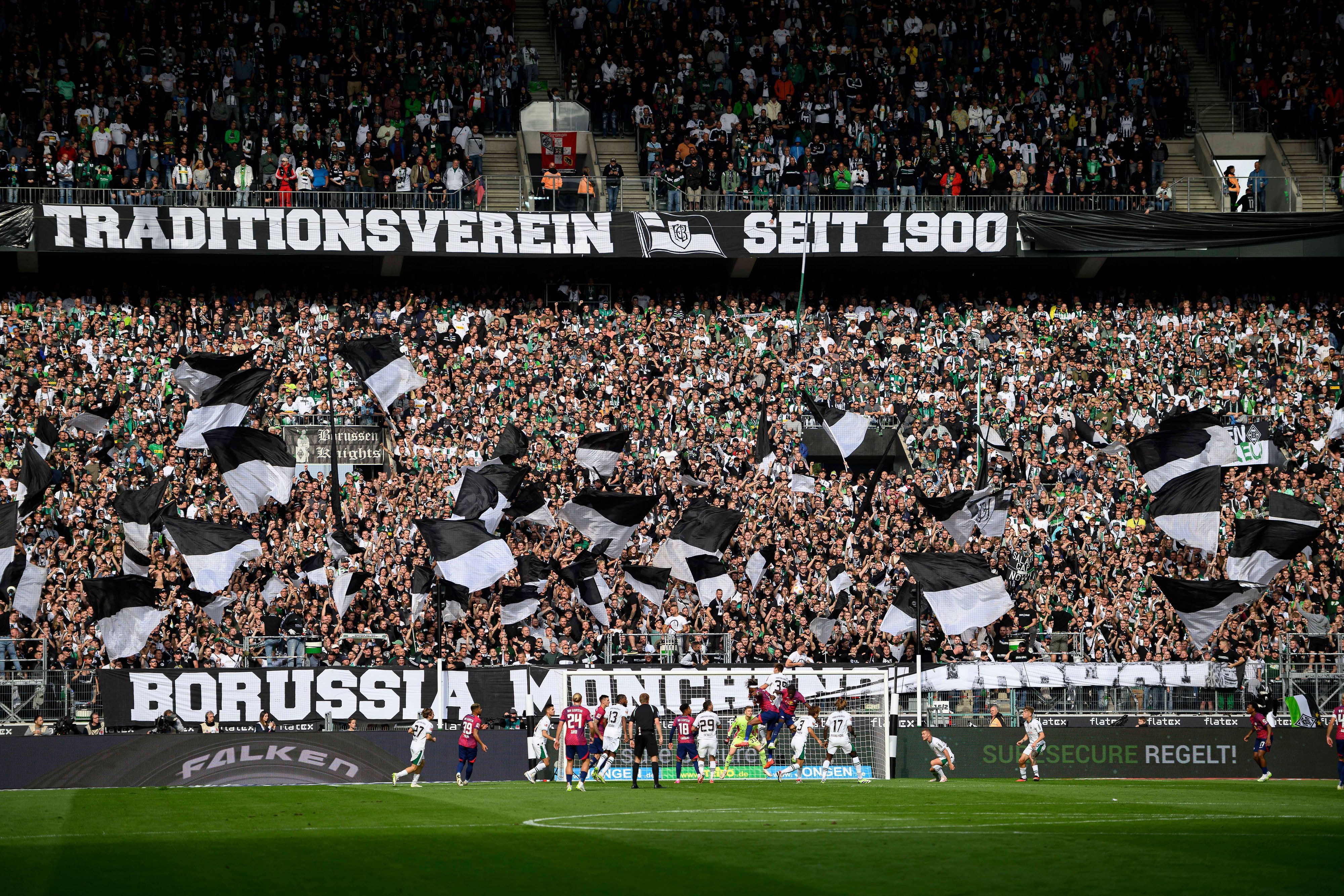 Die Nordkurve im Borussia-Park mit Fahnen und zwei großen Bannern.