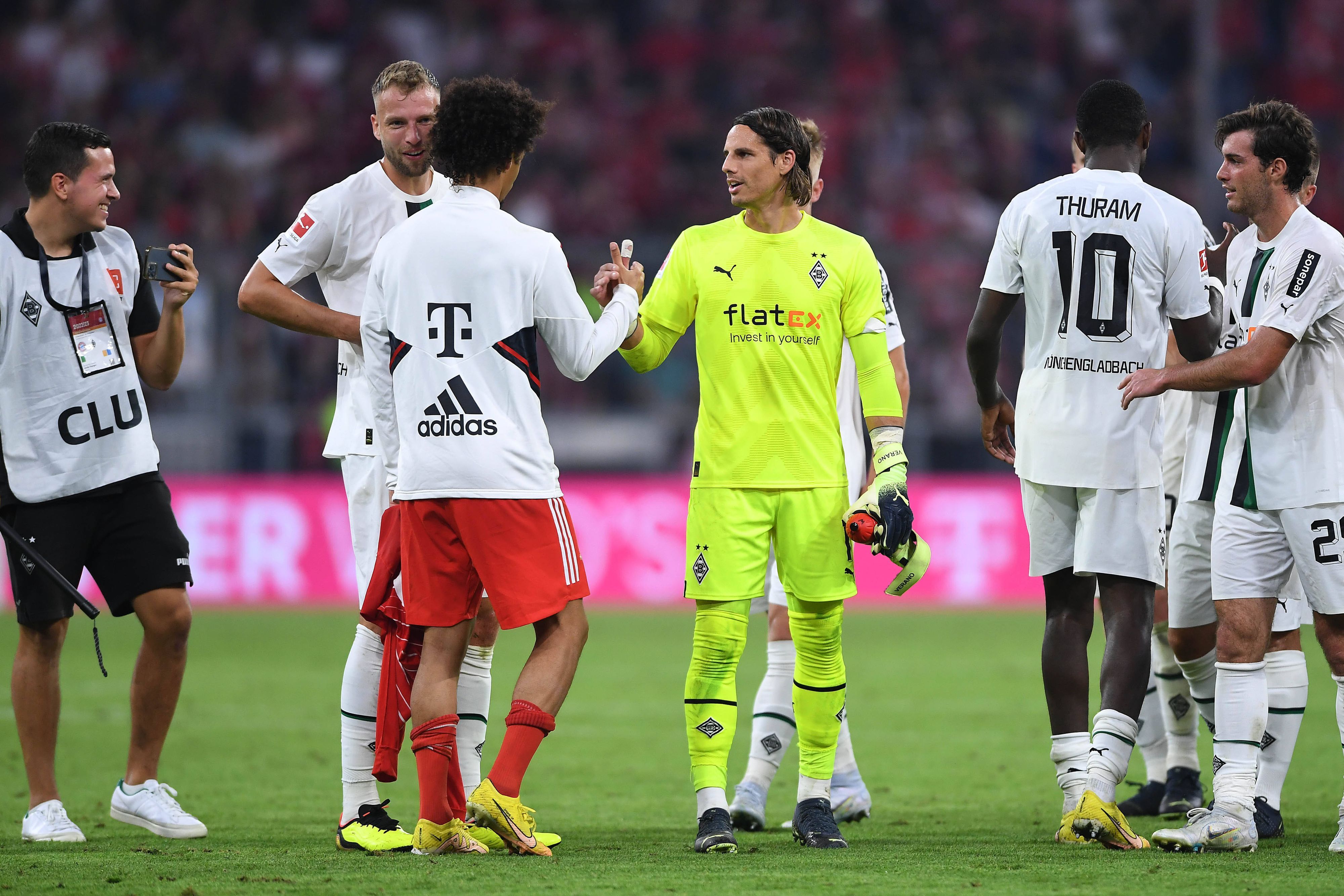 Spieler von Borussia Mönchengladbach klatschen nach Spielende mit einem Profi vom FC Bayern München ab.