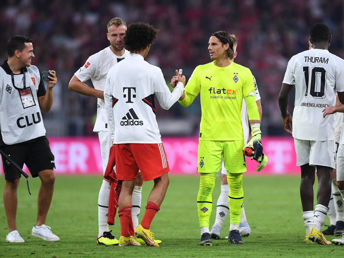 Spieler von Borussia Mönchengladbach klatschen nach Spielende mit einem Profi vom FC Bayern München ab.