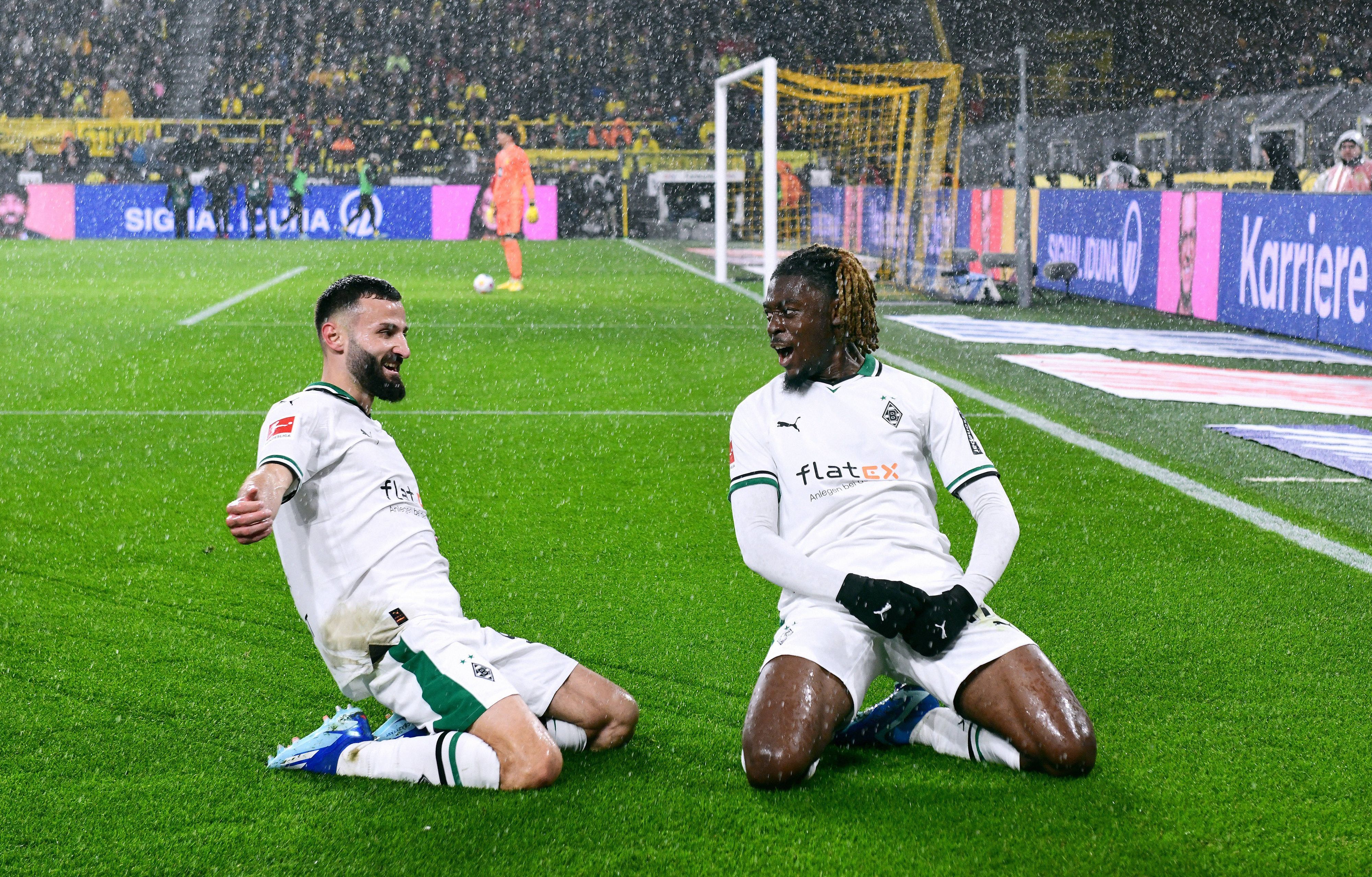 Franck Honorat und Manu Koné rutschen jubelnd über den Rasen im Signal-Iduna-Park in Dortmund.