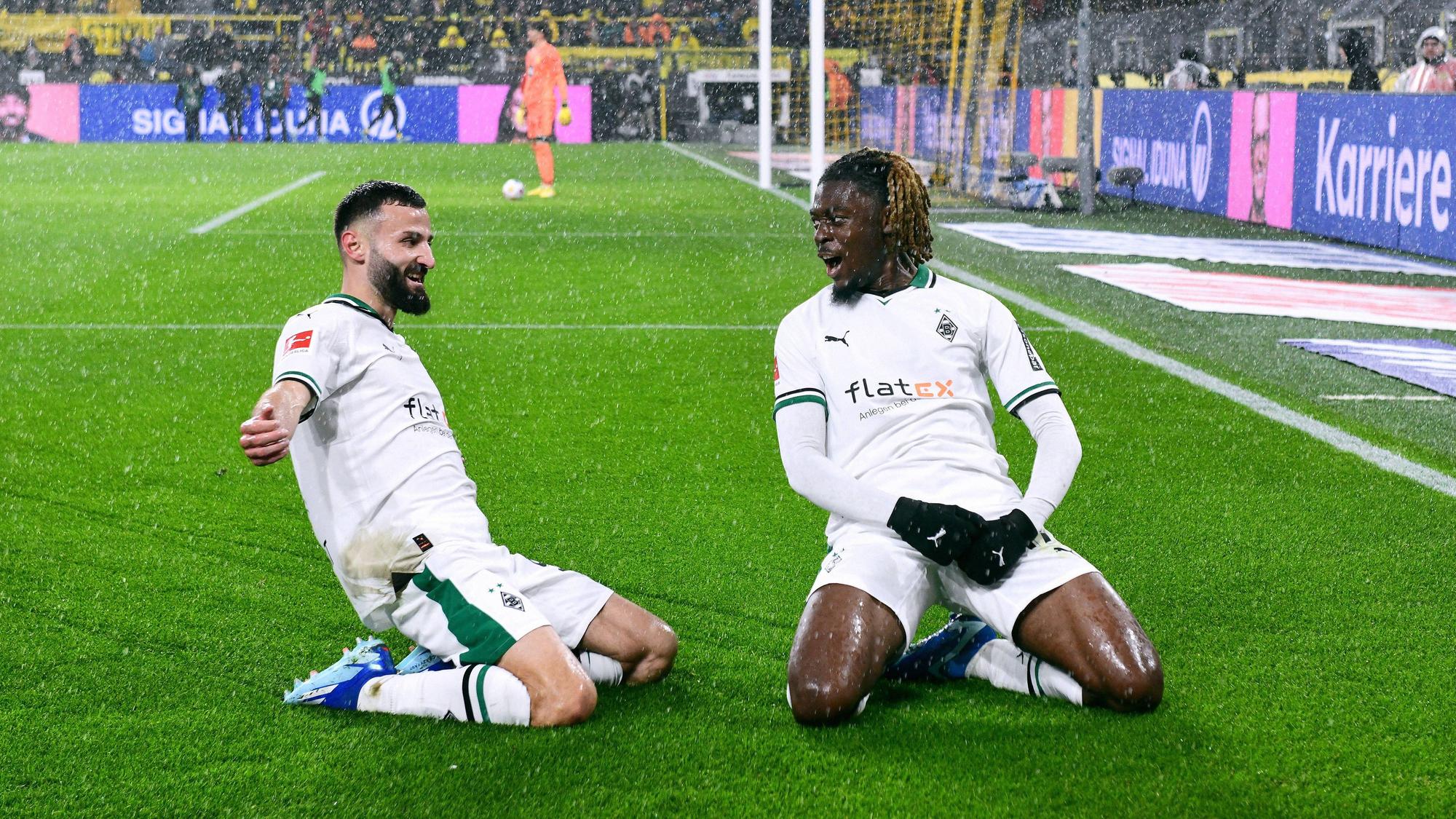 Franck Honorat und Manu Koné rutschen jubelnd über den Rasen im Signal-Iduna-Park in Dortmund.