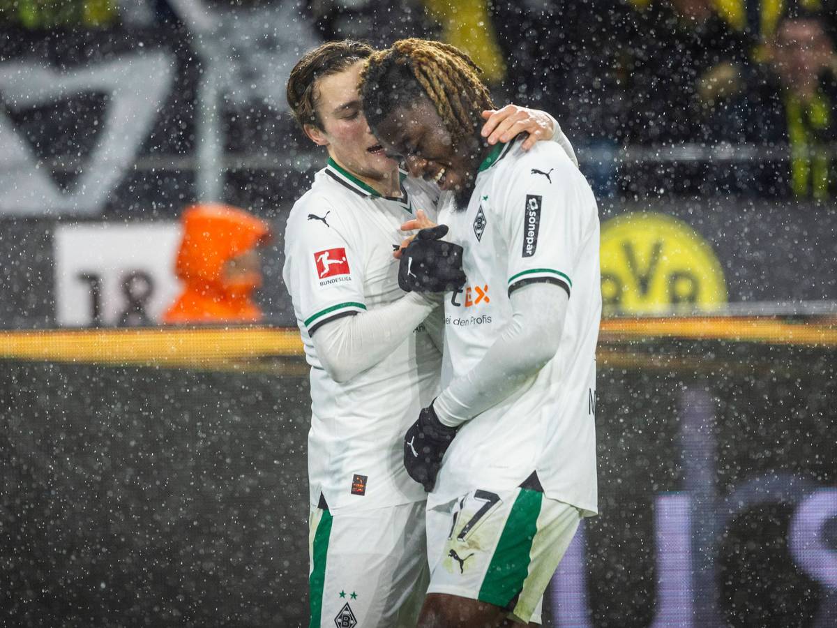 Rocco Reitz und Manu Kone schlagen im Dortmunder Stadion miteinander ein. Es regnet.