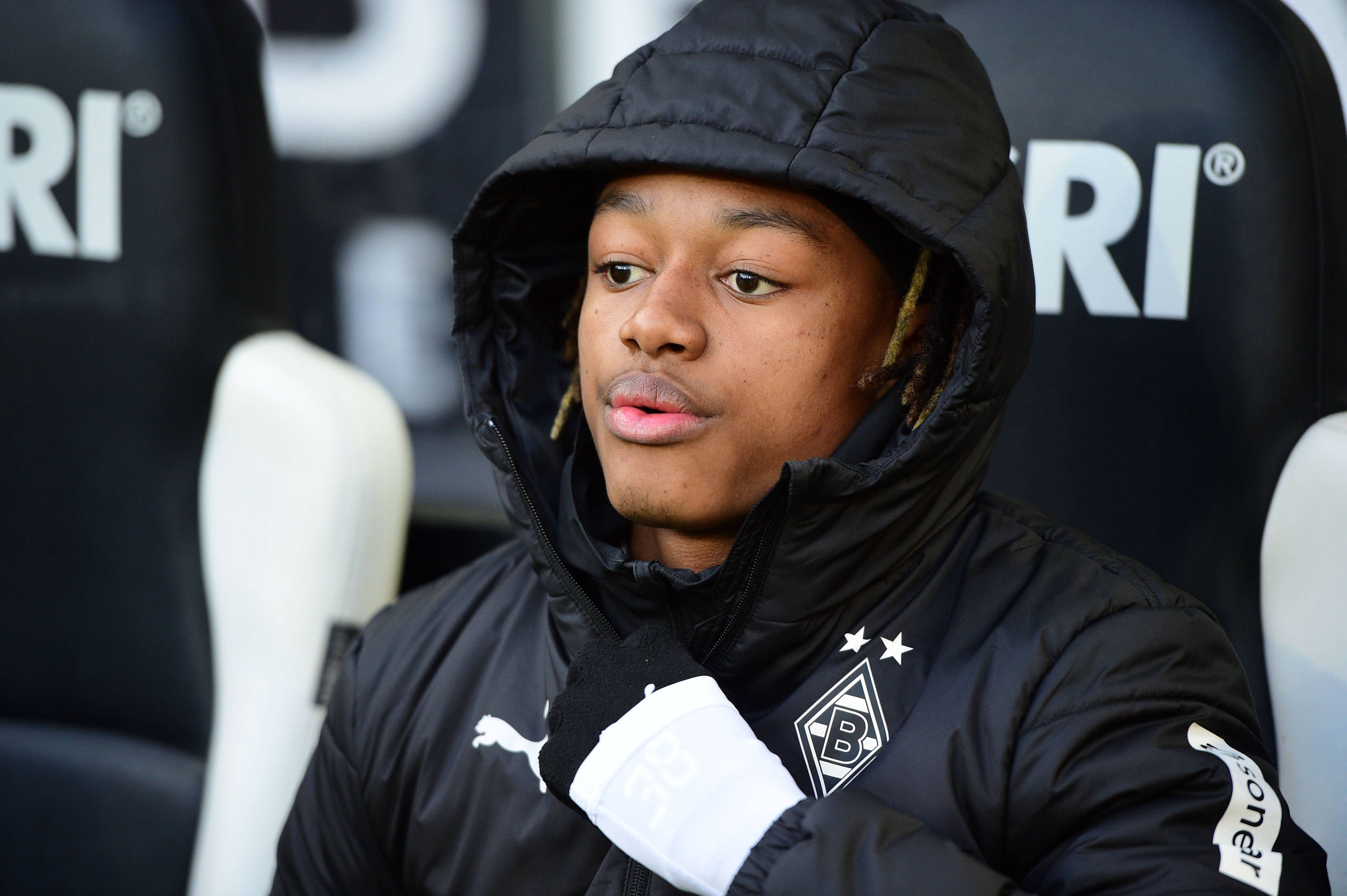 Yvandro Borges Sanches sitzt in einer Borussia-Jacke auf der Auswechselbank.