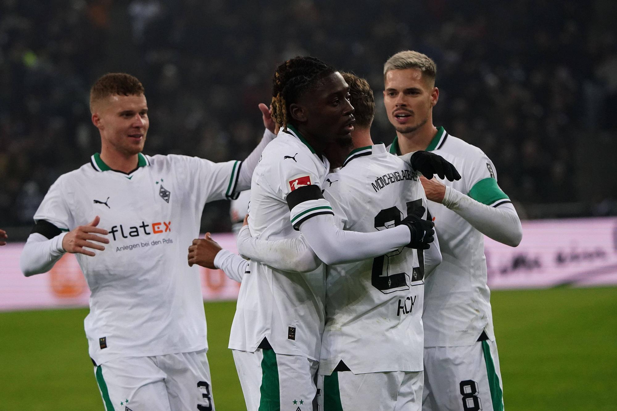 Manu Koné und Julian Weigl herzen den Torschützen Robin Hack nach einem Tor.
