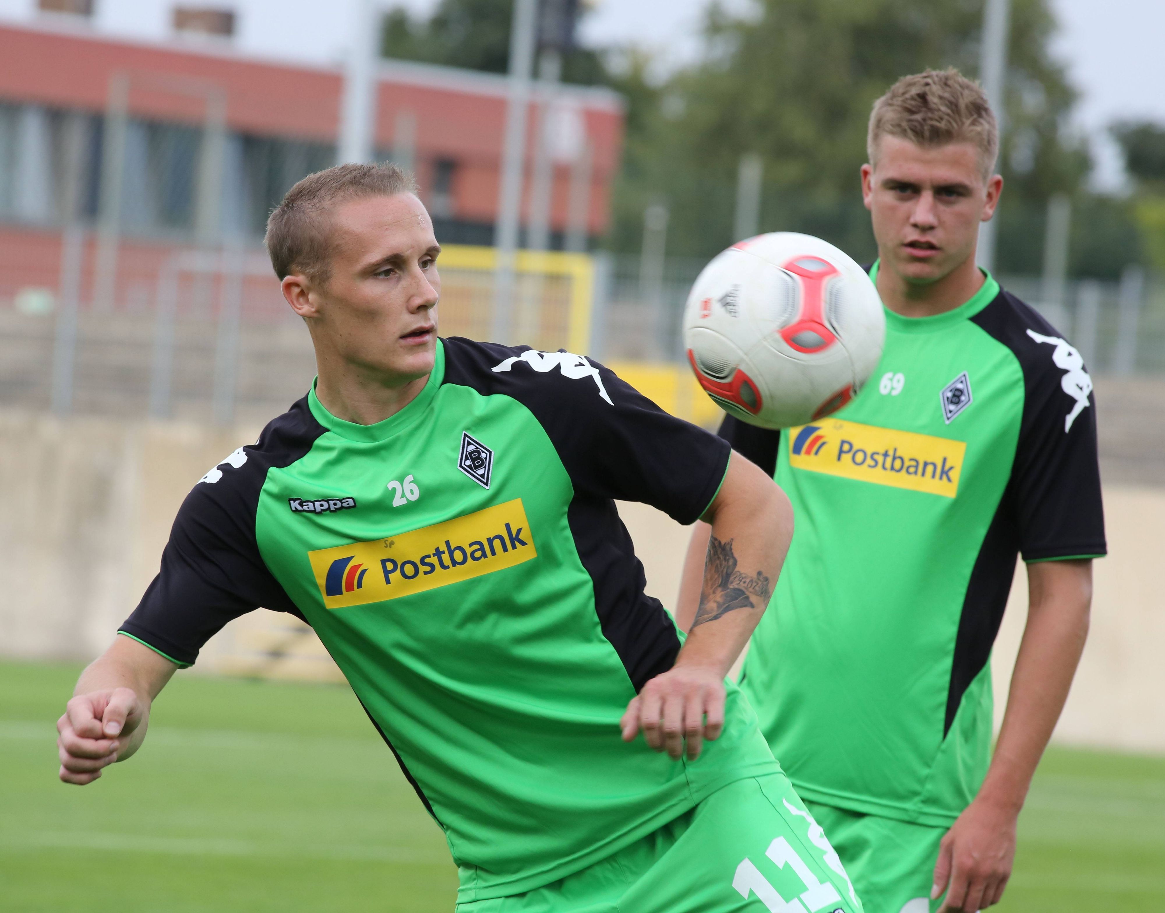 Sven Michel hält einen Ball hoch, Maik Odenthal schaut im Hintergrund zu.
