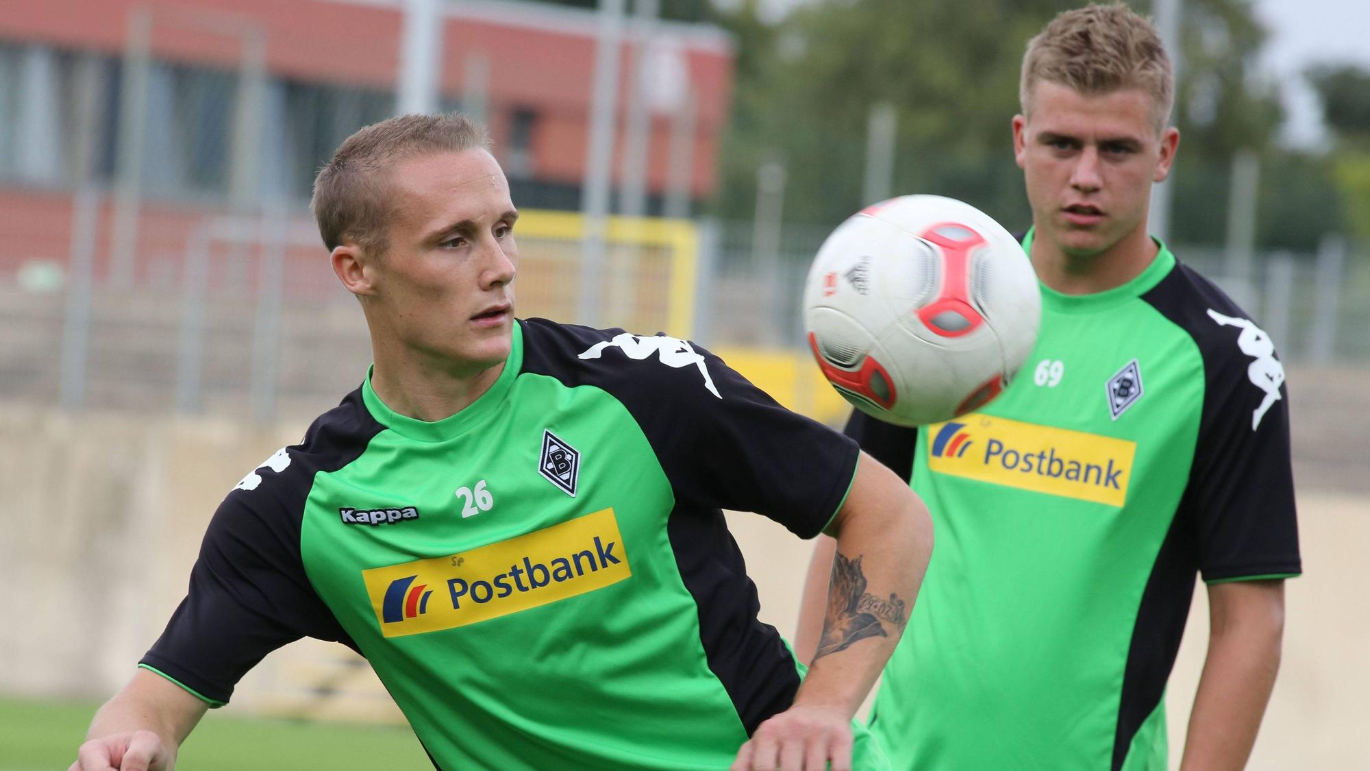 Sven Michel hält einen Ball hoch, Maik Odenthal schaut im Hintergrund zu.