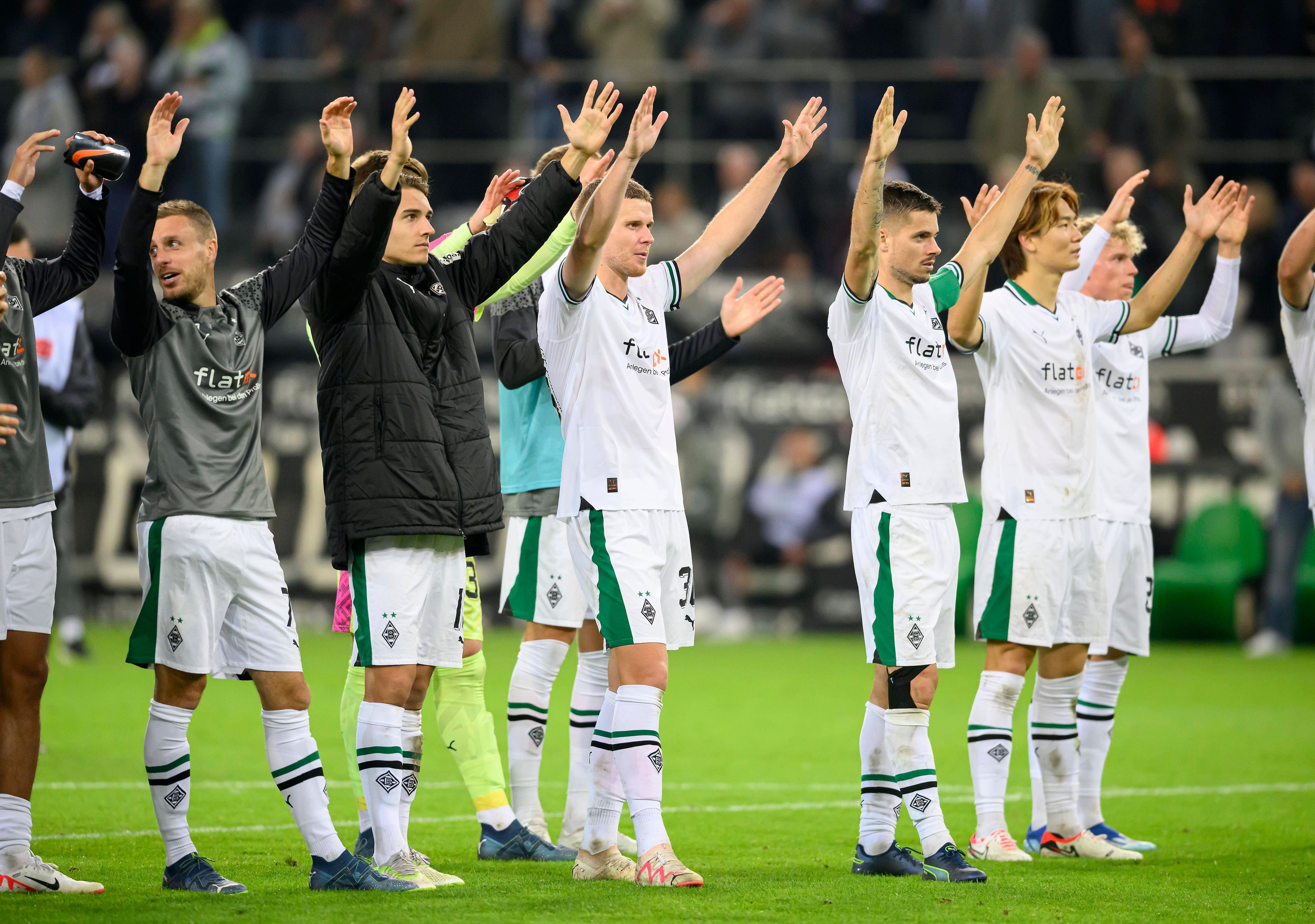Borussia-Spieler heben die Arme.