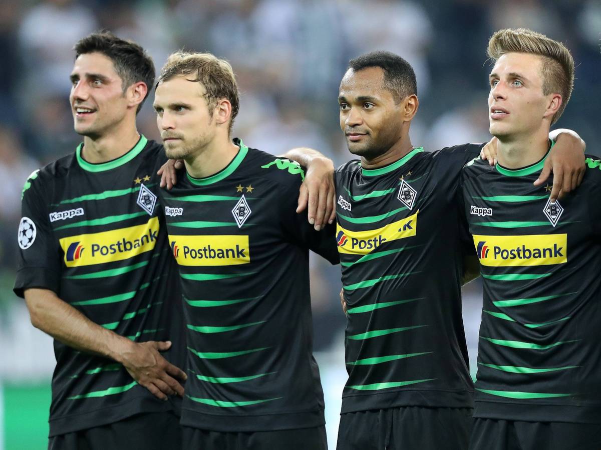 Spieler von Borussia Mönchengladbach bilden eine Reihe nebeneinander stehend.