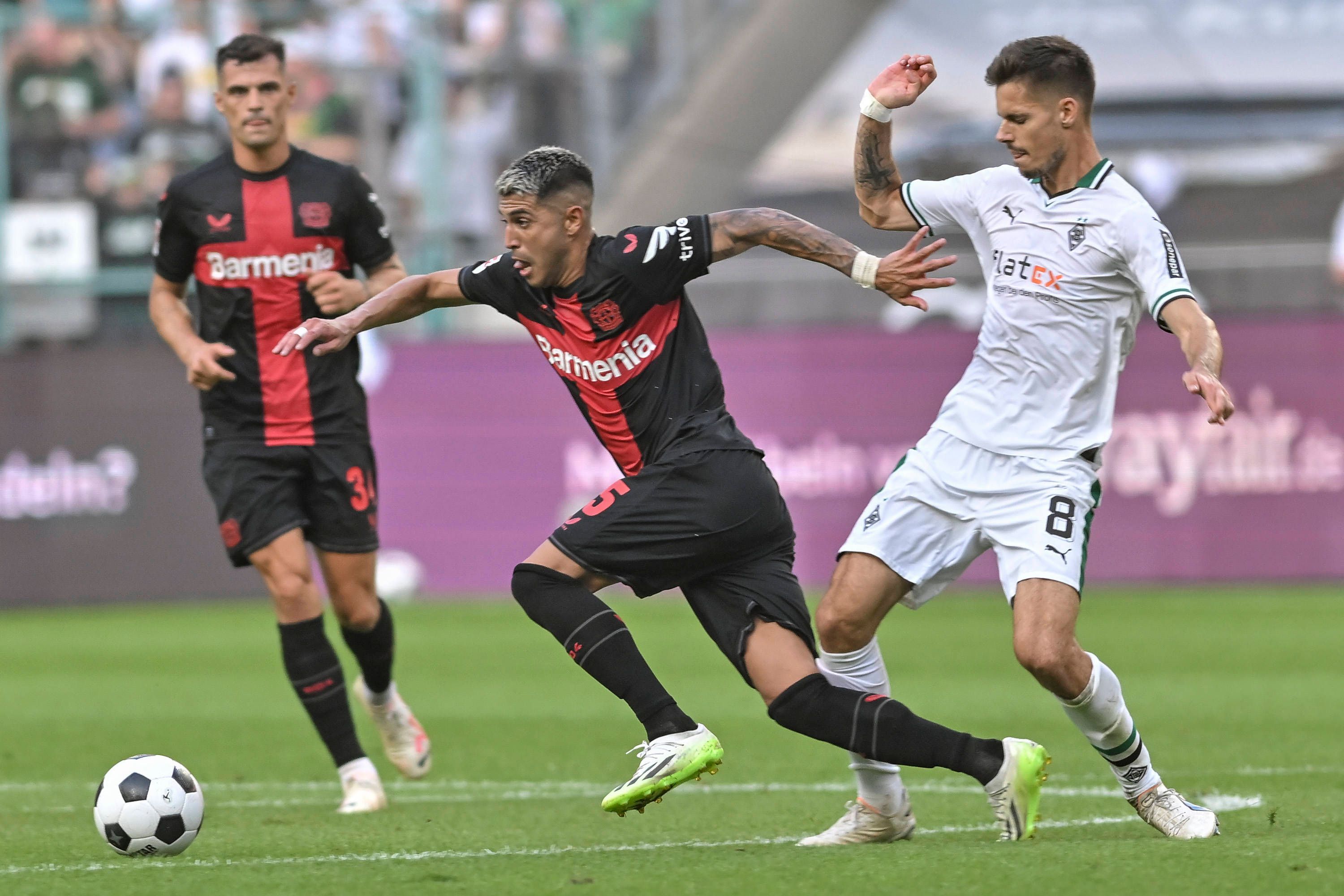 Exequiel Palacios dribbelt, Julian Weigl versucht ihn zu stoppen und trifft ihn am Unterschenkel.