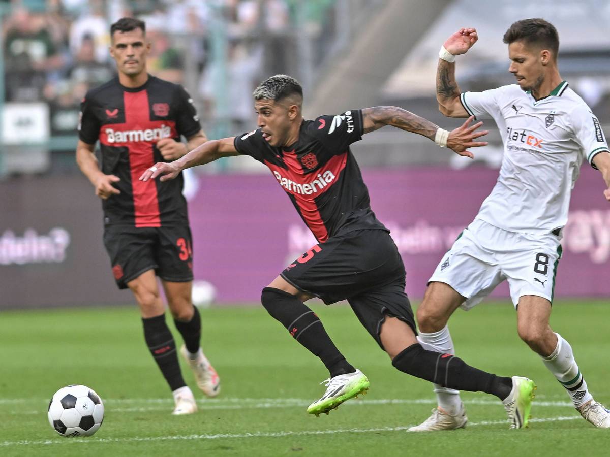Exequiel Palacios dribbelt, Julian Weigl versucht ihn zu stoppen und trifft ihn am Unterschenkel.