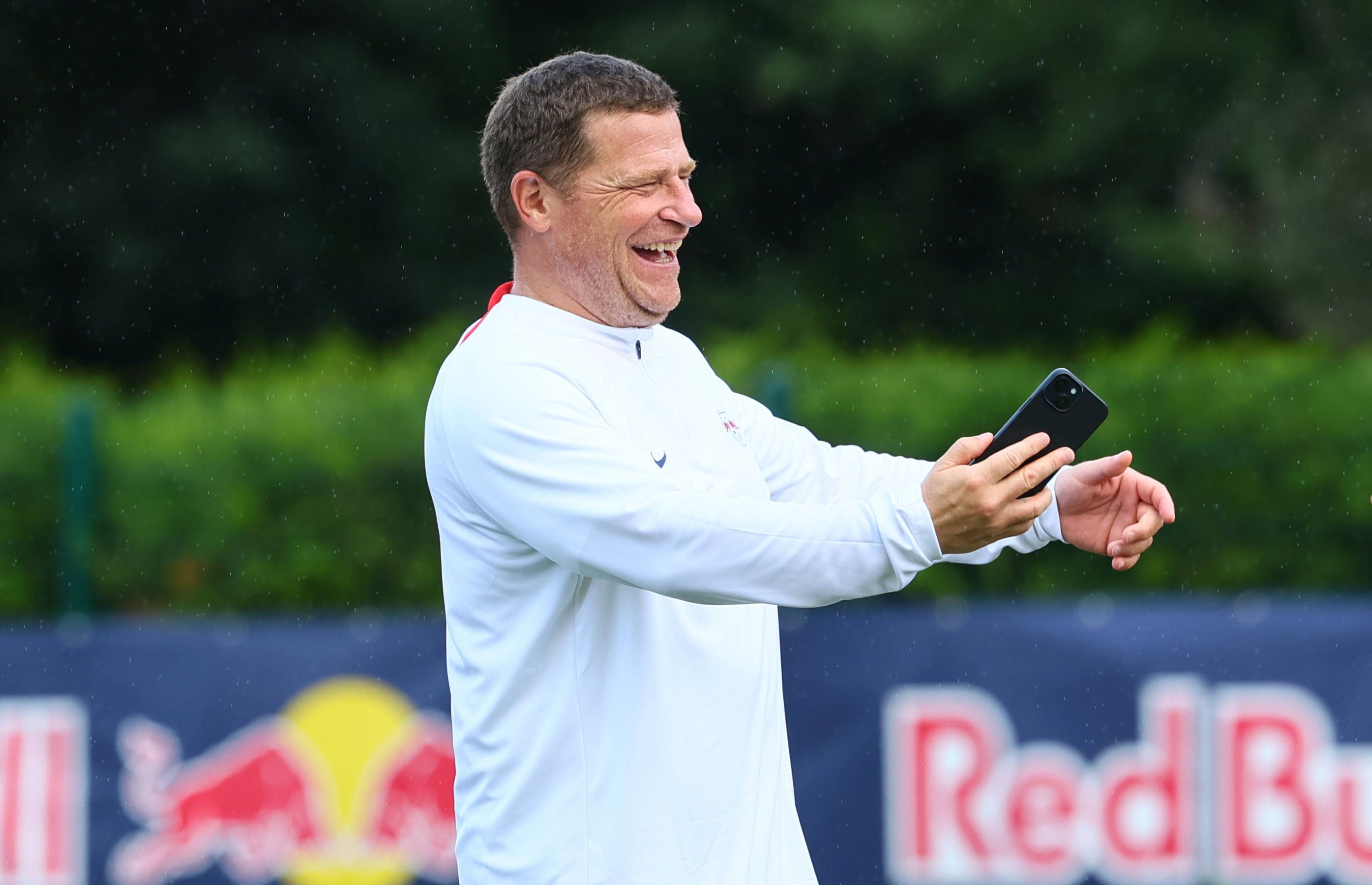 Max Eberl hält ein Handy in der Hand.