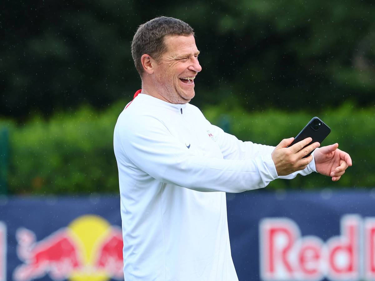 Max Eberl hält ein Handy in der Hand.