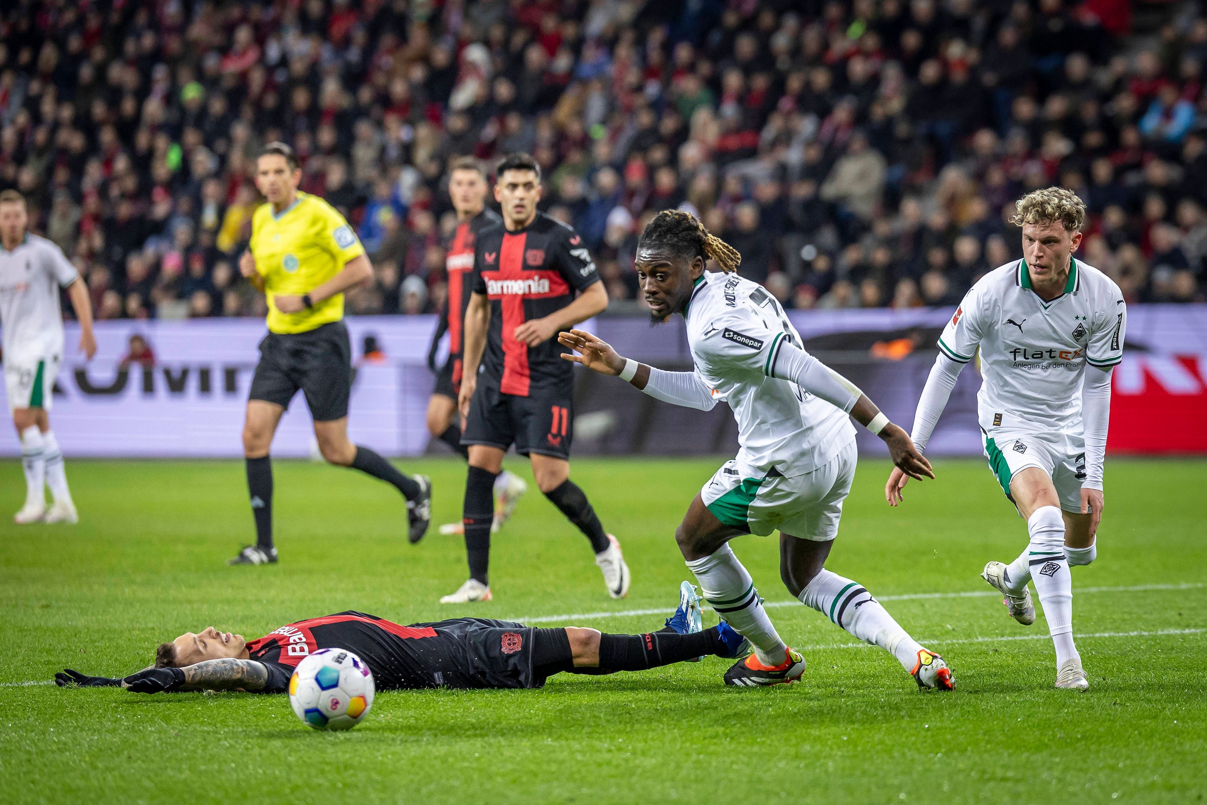 Manu Koné und Robin Hack blicken auf den Ball.
