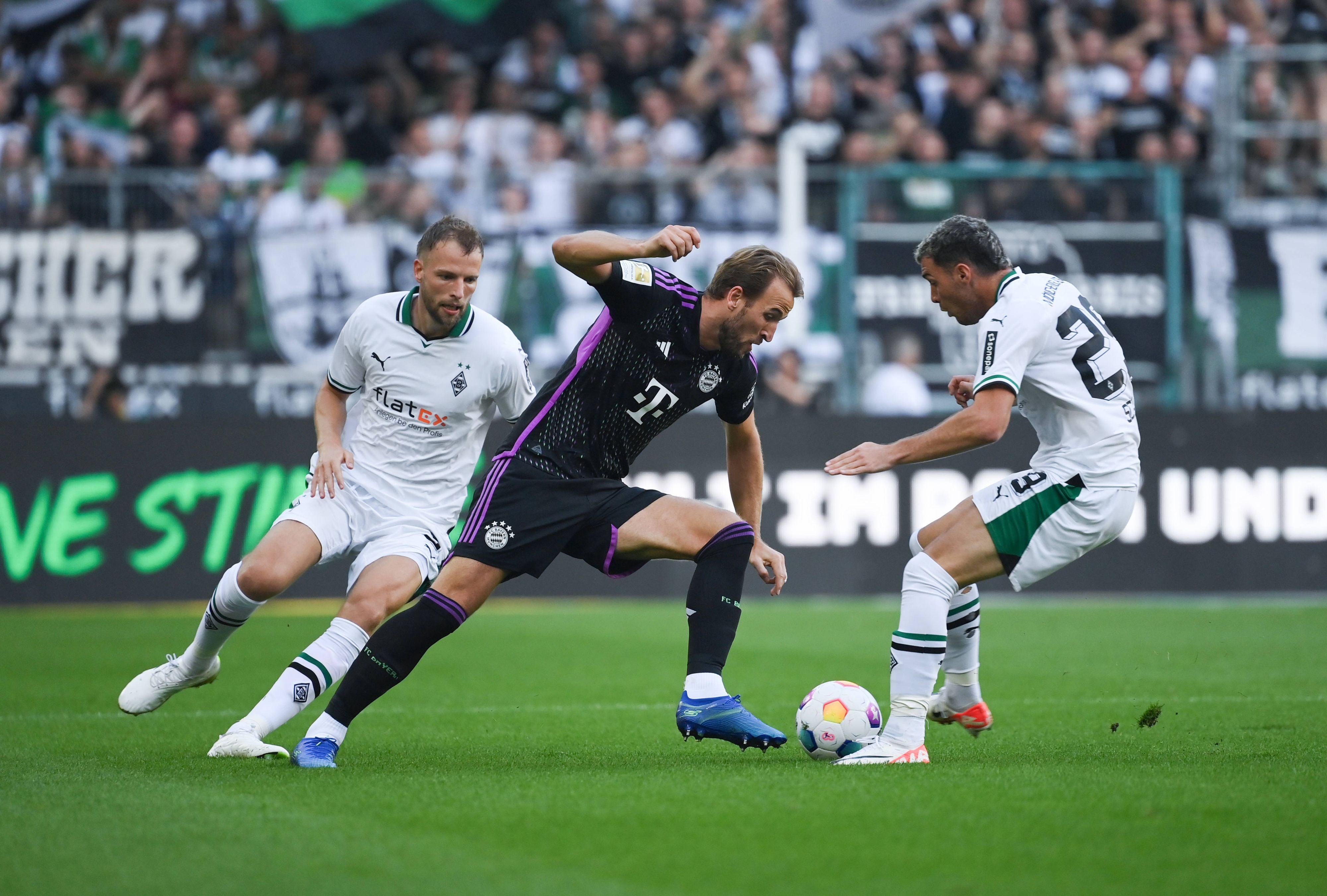 Joe Scally und Marvin Friedrich versuchen, Harry Kane vom Ball zu trennen.