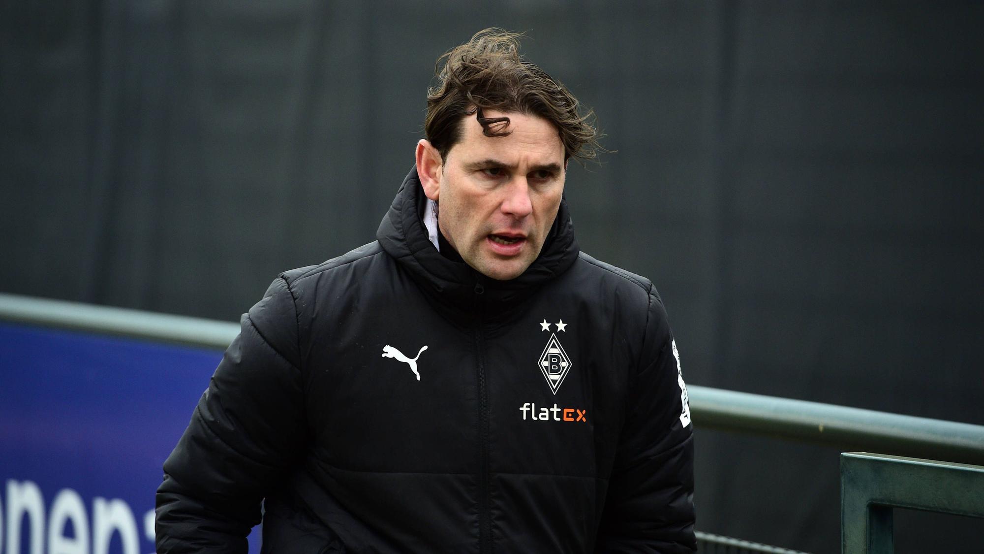 Trainer von Borussia Mönchengladbach schaut erschöpft beim Training.