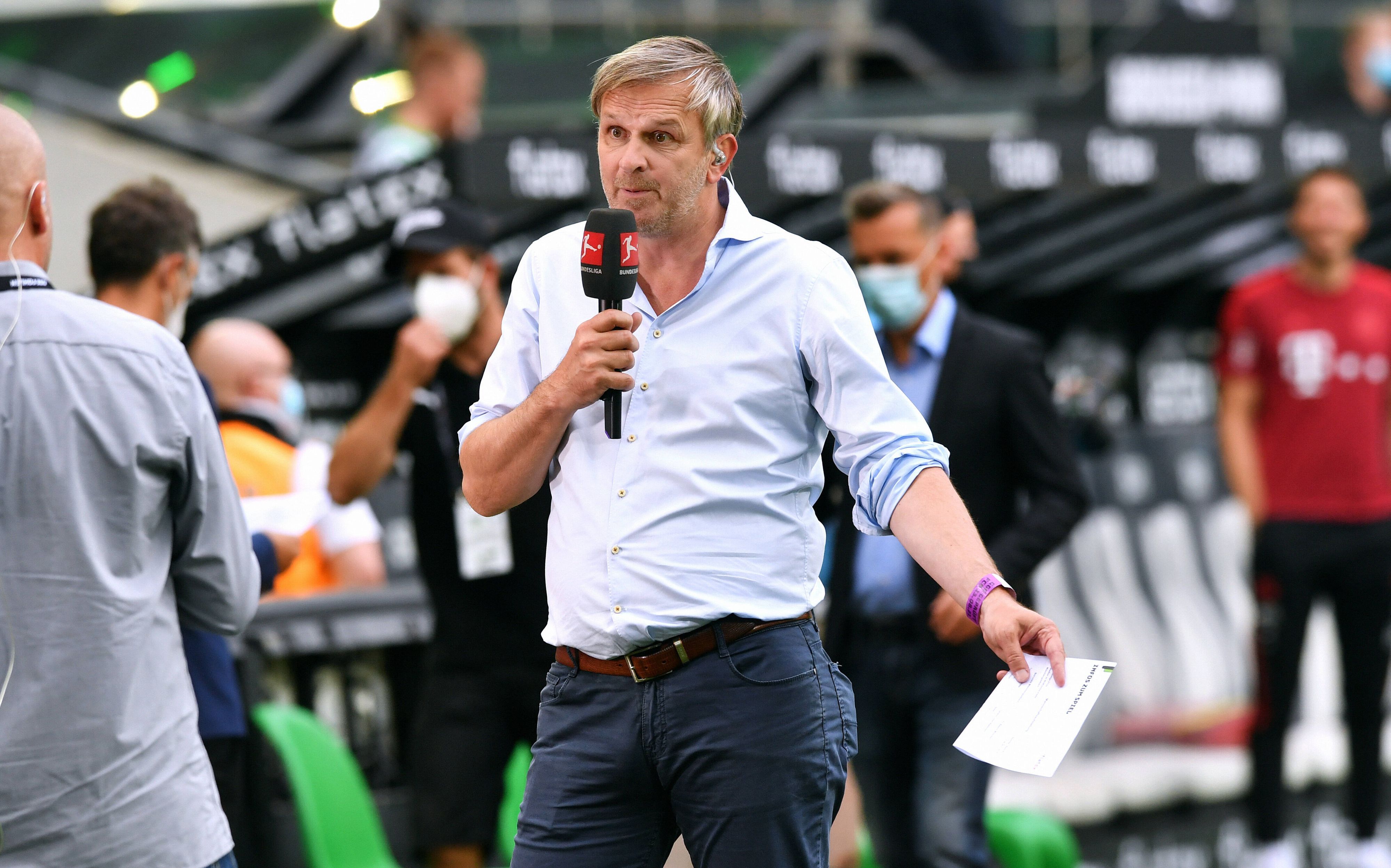 Didi Hamann mit einem Mikrofon in der Hand.