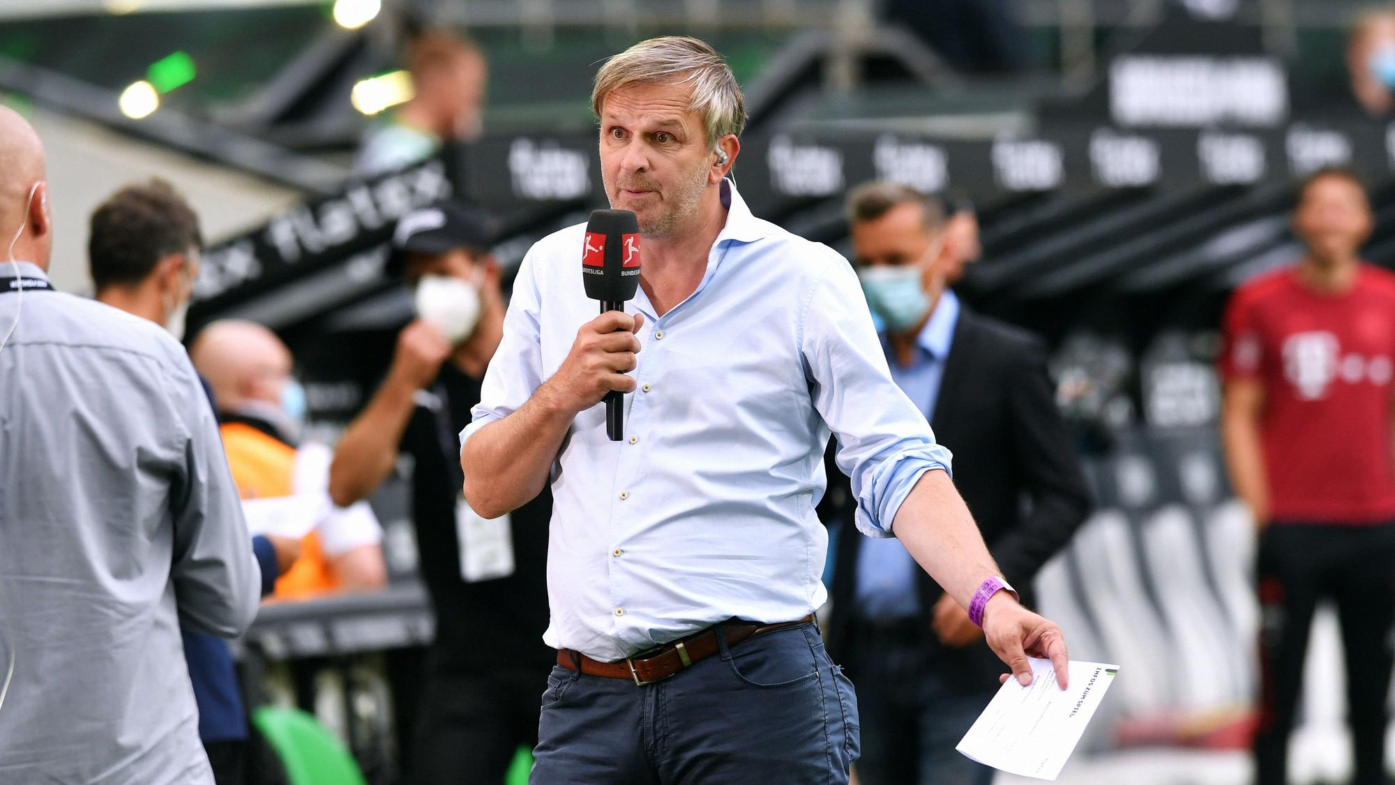 Didi Hamann mit einem Mikrofon in der Hand.