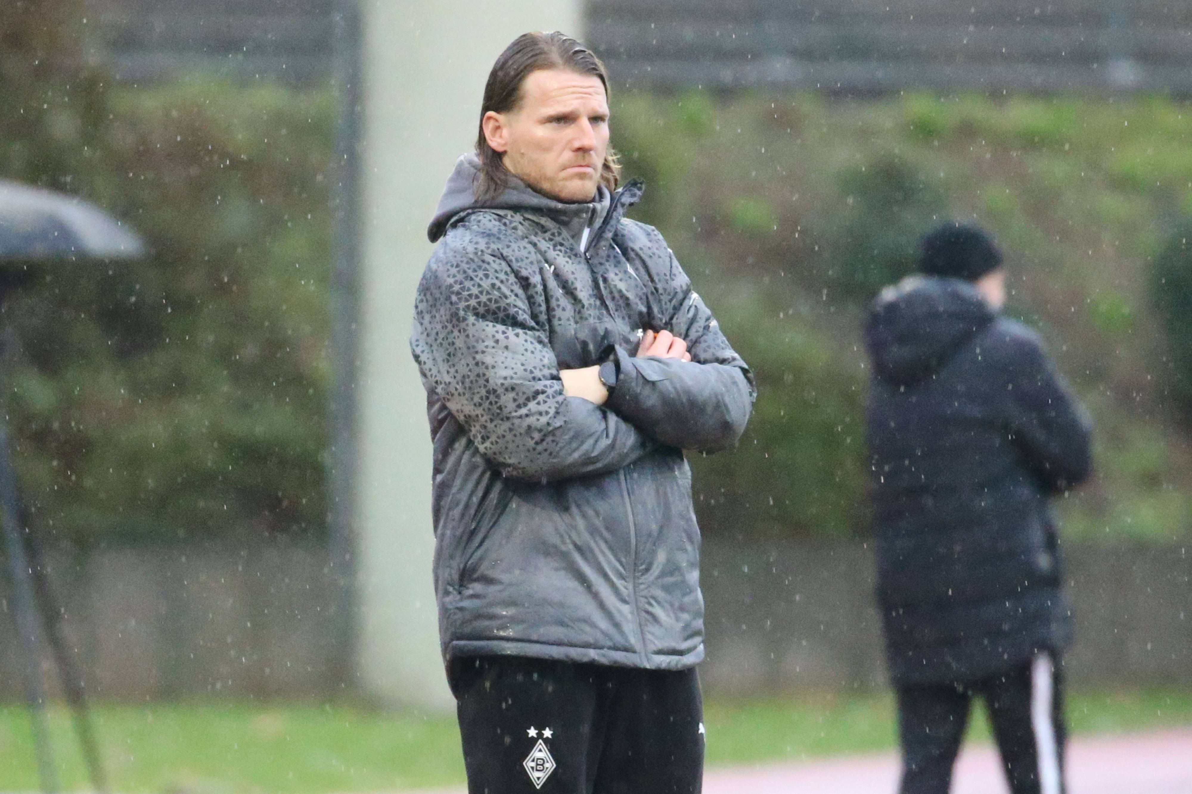 U23 Coach von Borussia Mönchengladbach steht im Regen.