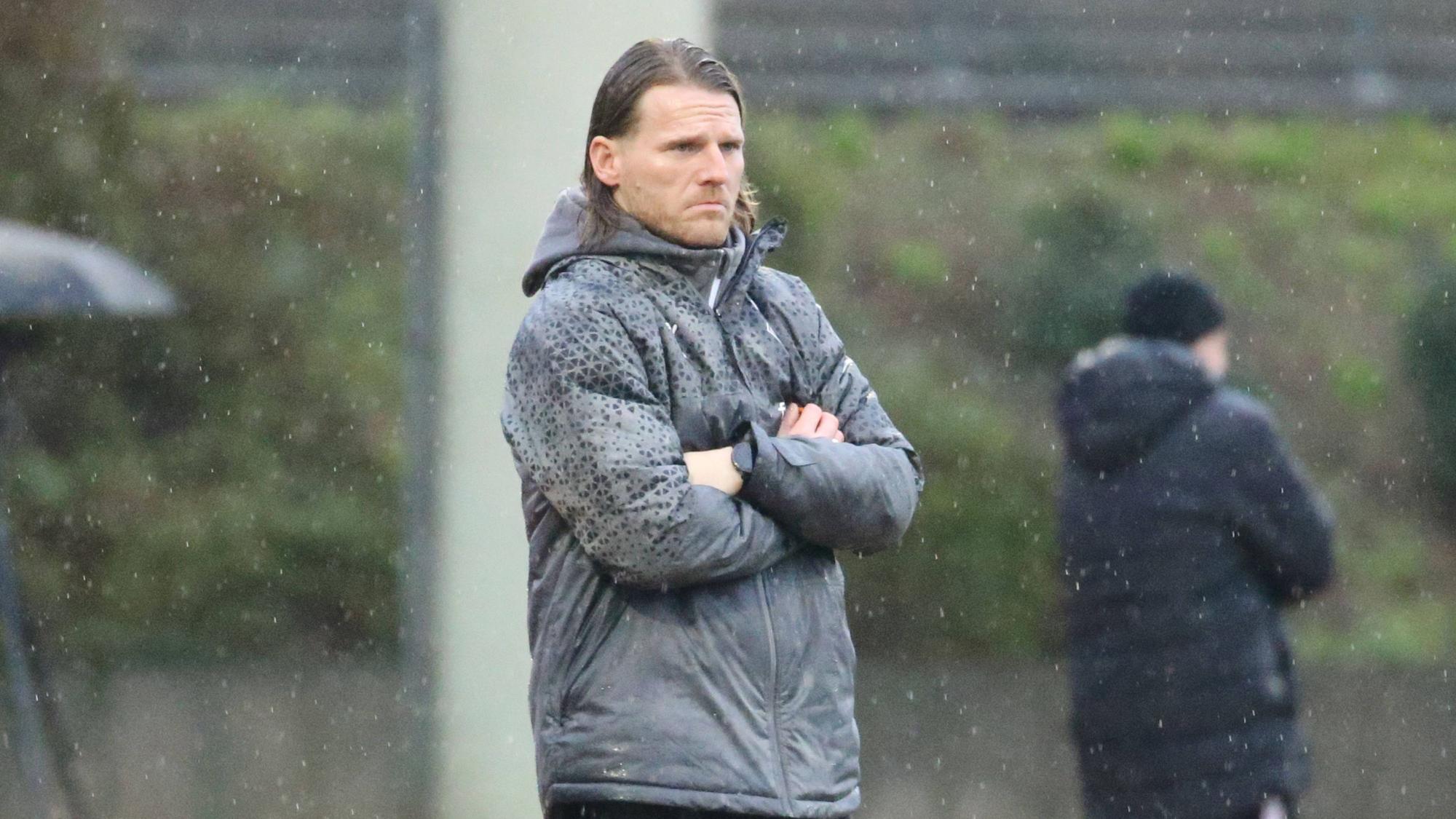 U23 Coach von Borussia Mönchengladbach steht im Regen.