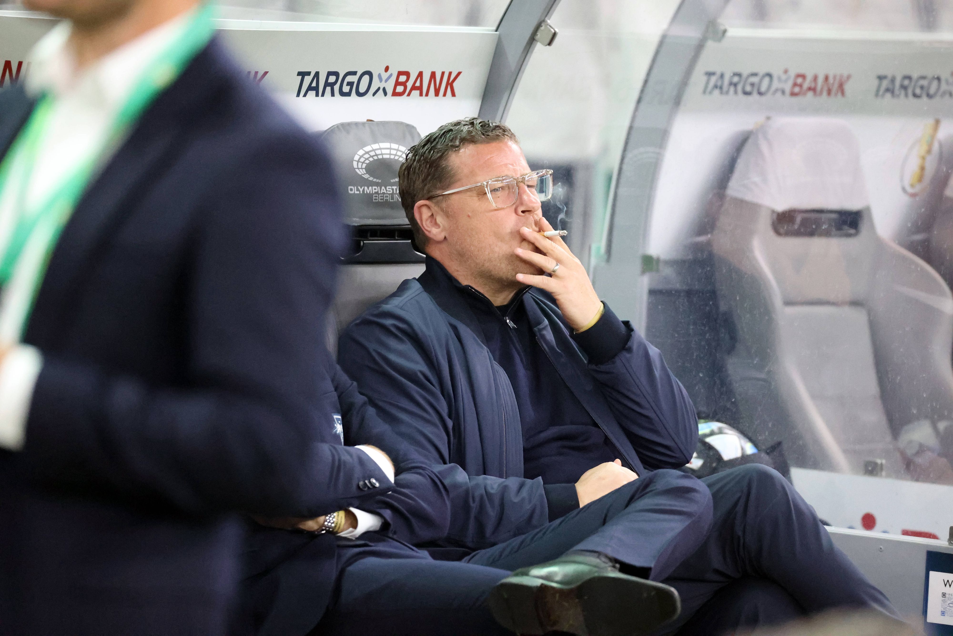 Max Eberl mit einer Zigarette im Mund.