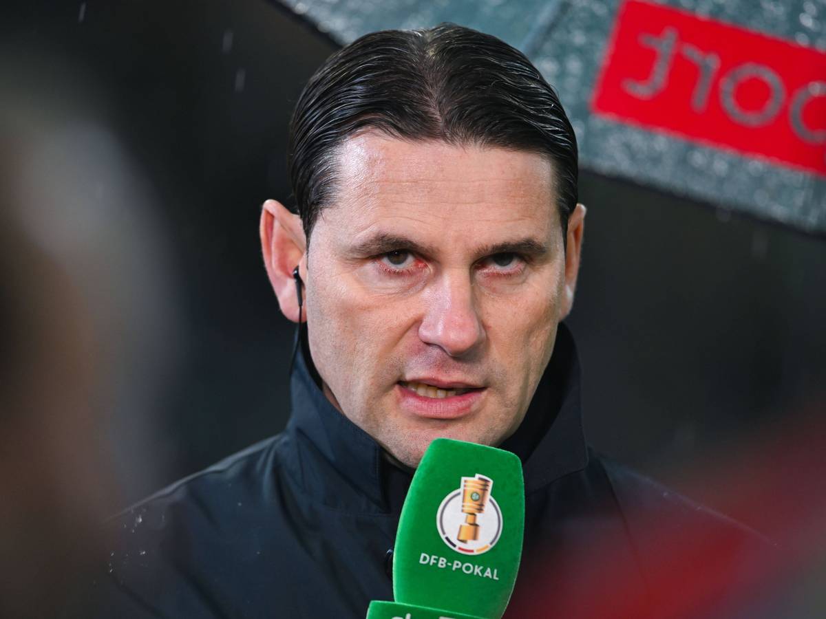 Trainer von Borussia Mönchengladbach spricht in ein Mikrofon.