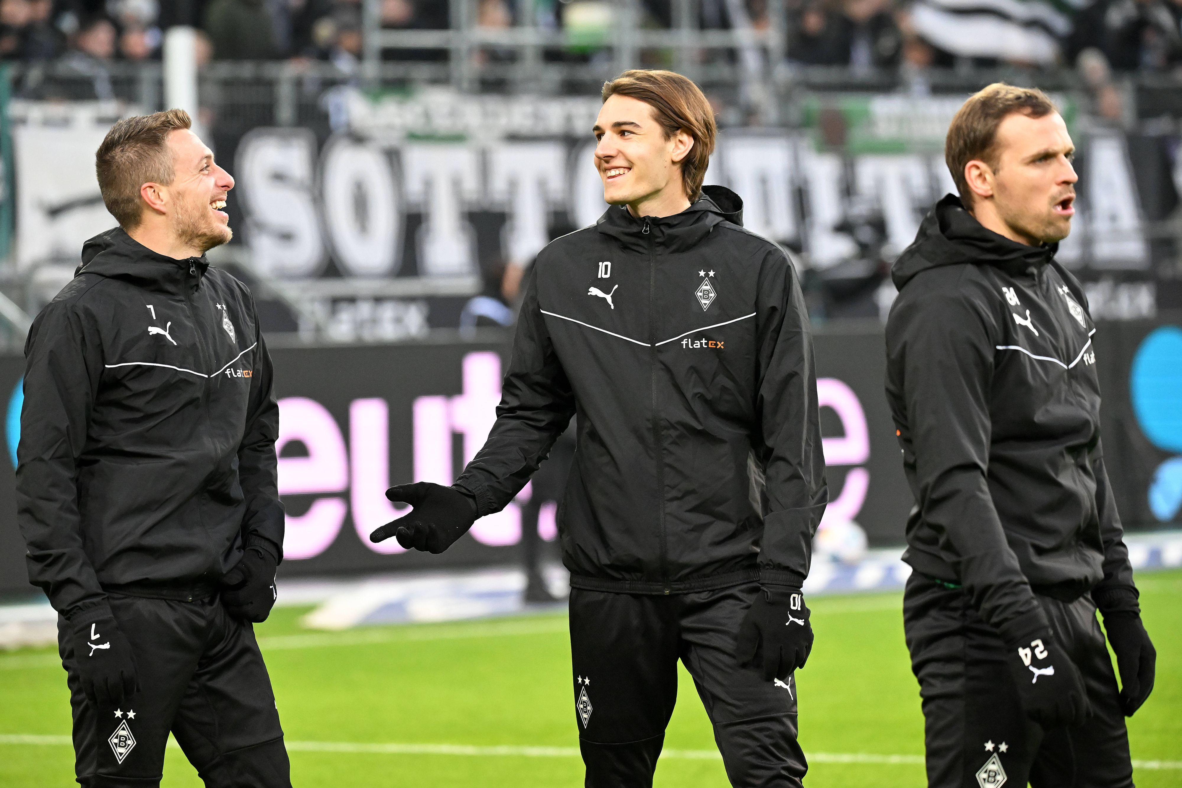 Profis von Borussia Mönchengladbach im Gespräch und lachen.