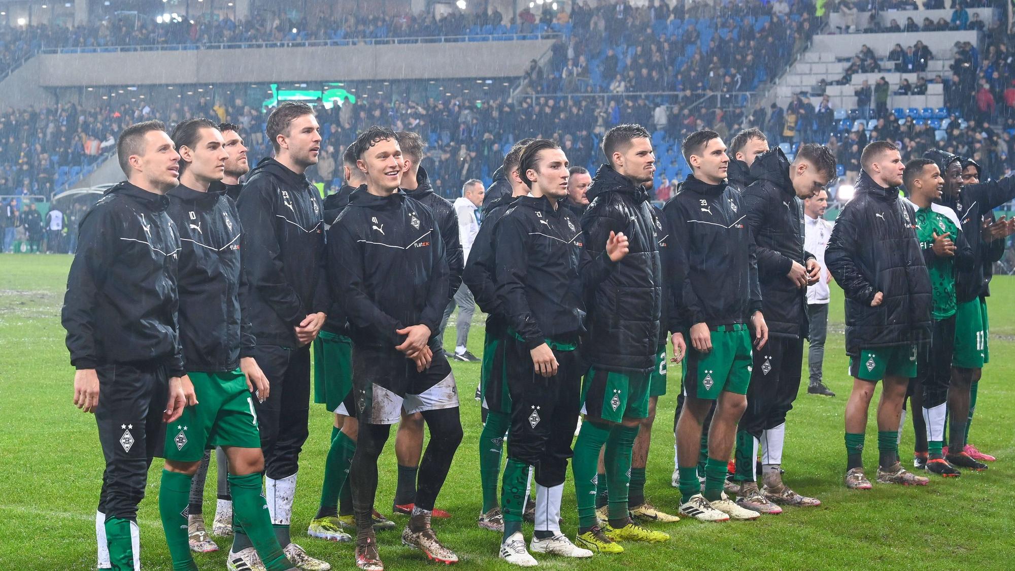 Spieler von Borussia Mönchengladbach stehen bei den Fans.