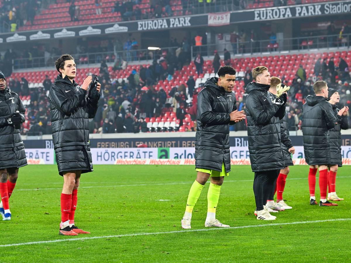 Spieler des SC Freiburg vor der Fankurve.